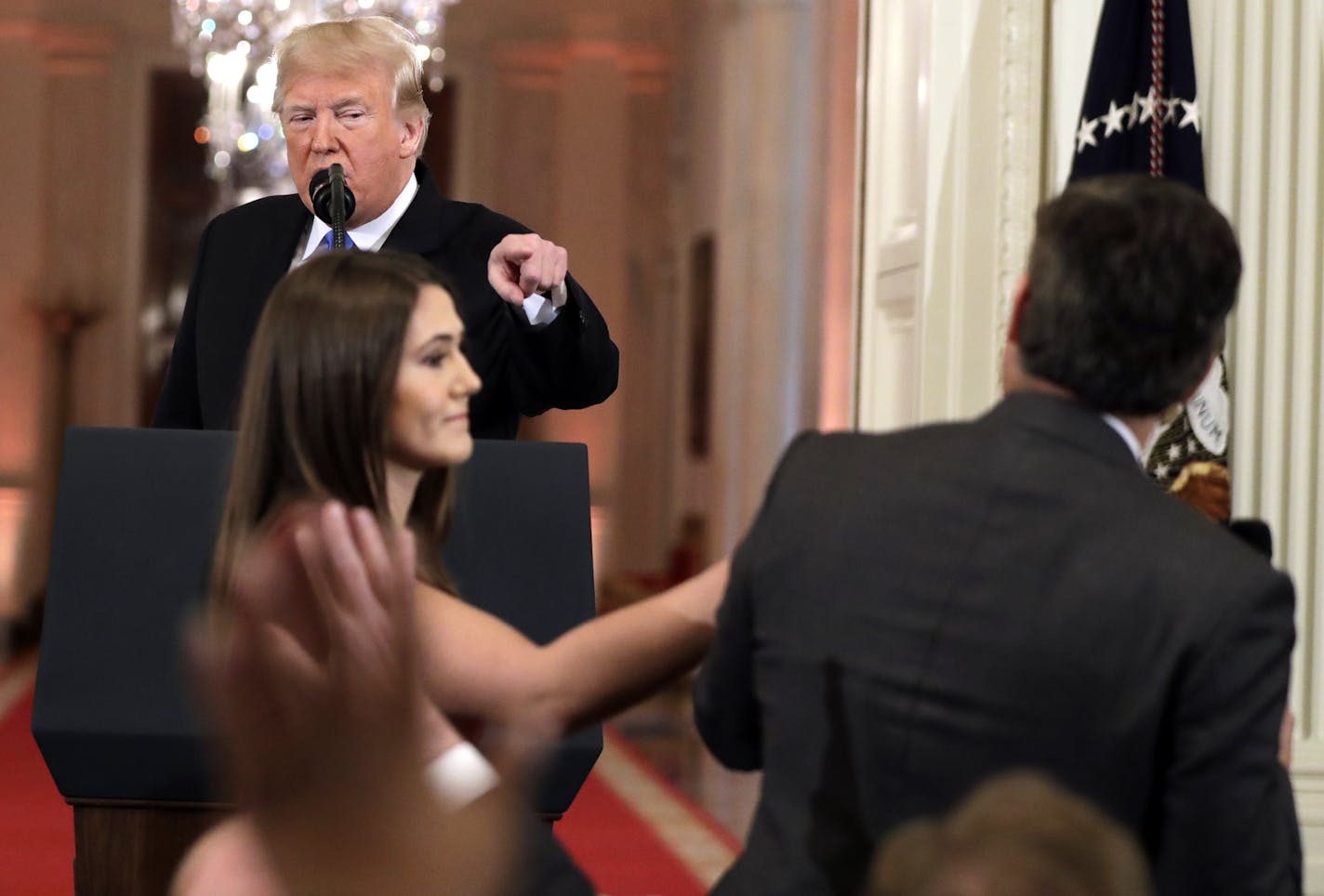 As President Donald Trump points to CNN's Jim Acosta, a White House aide takes the microphone from him during a news conference in the East Room of the White House, Wednesday, Nov. 7, 2018, in Washington. (AP Photo/Evan Vucci)