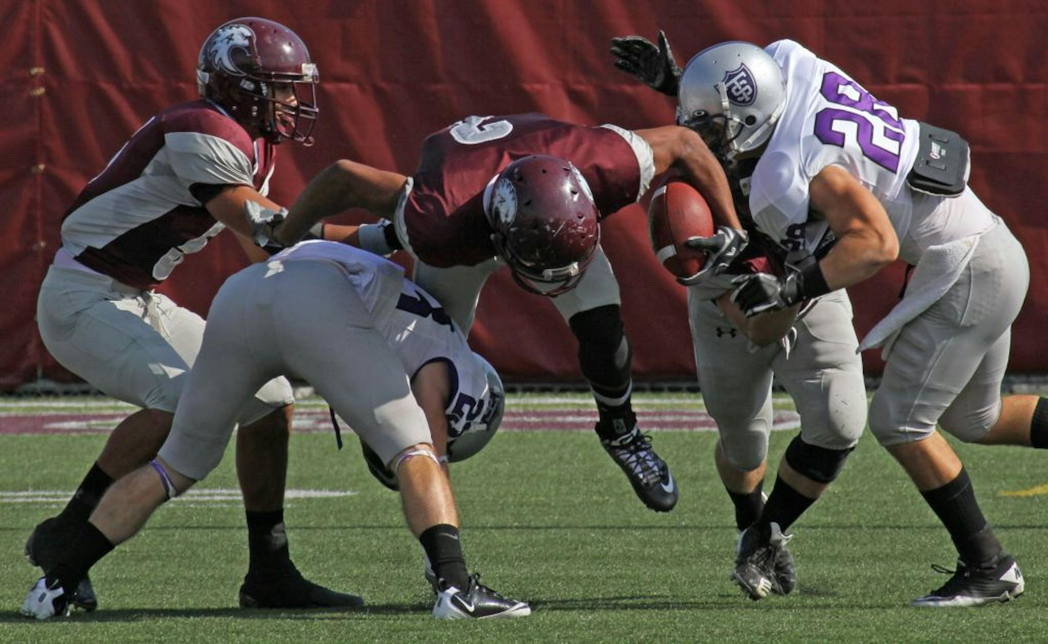(center) Augsburg's Hakeem Bourne-McFarlane was tripped up as he returned a punt in first half action against St. Thomas on 10/8/11.