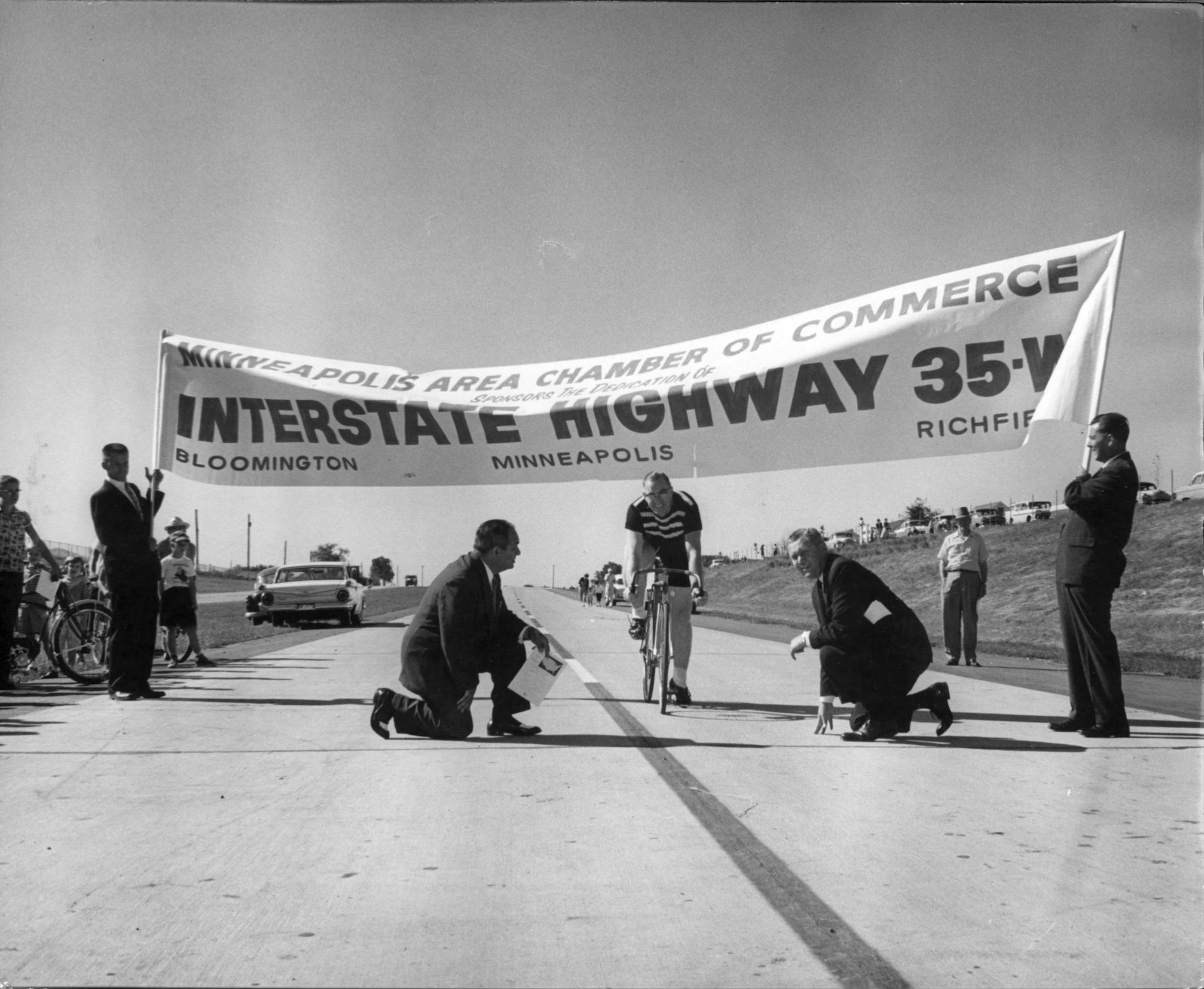 Opening of Interstate Highway 35W. Minneapolis STAR photo by Bonham Cross, August 17, 1959. -- Minneapolis, Richfield, and Bloomington joined hands today in opening the Metropolitan area's first stretch of freeway, from 56th Street to 106th Street. In ceremonies at the West 86th Street Bridge, the first official crossing was made by Torchy Peden, retired champion bicycle racer, who rode through the banner that served as the "ribbon."