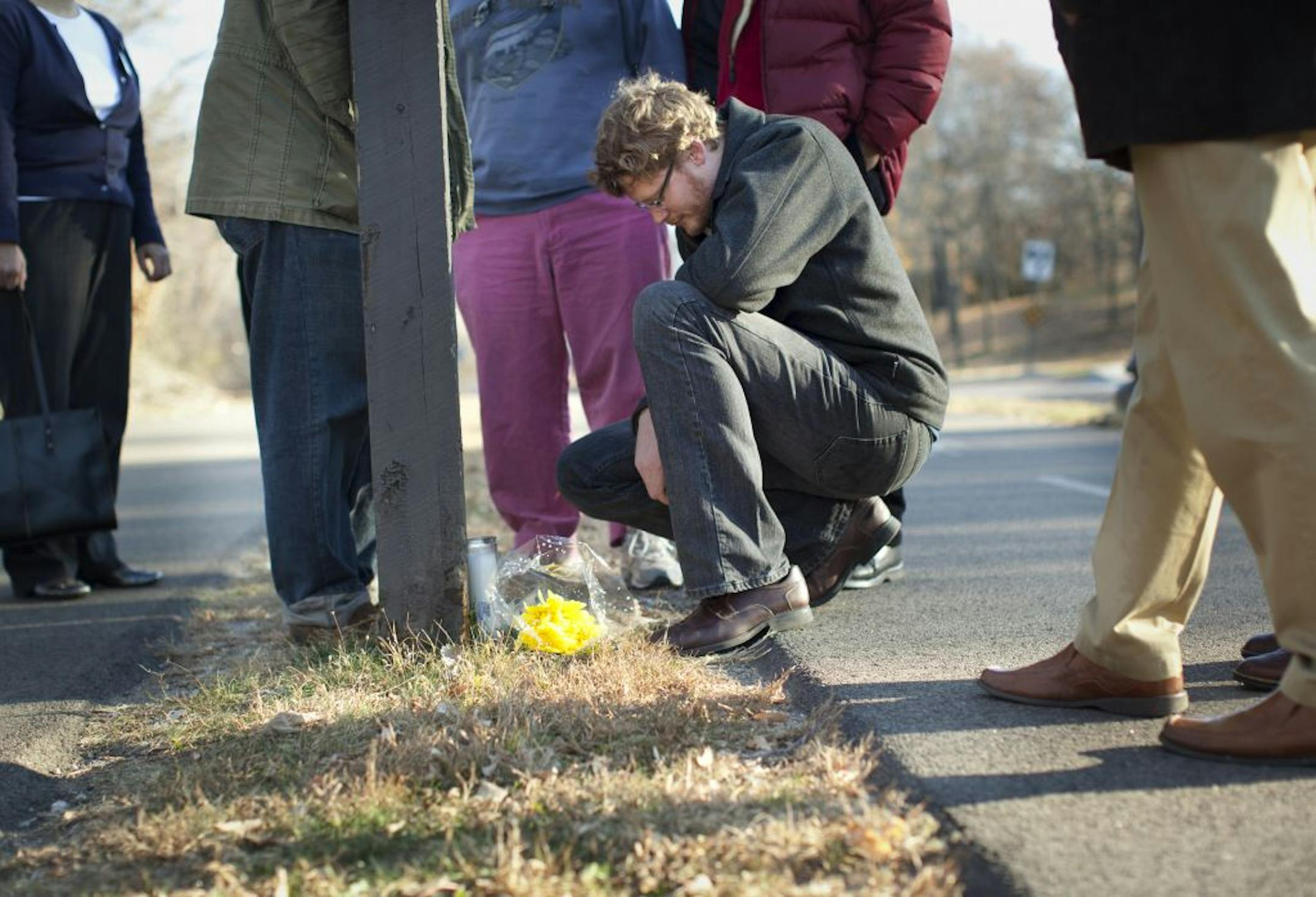 Michael Buller, 28, lit a candle for his uncle Thomas Malloy who was killed in a hit and run accident at that spot on West River Parkway on Saturday while walking his bike across the street. On Monday, November 14, 2011 in Minneapolis, Minn., Buller walked to the accident scene with his classmates from Luther Seminary.