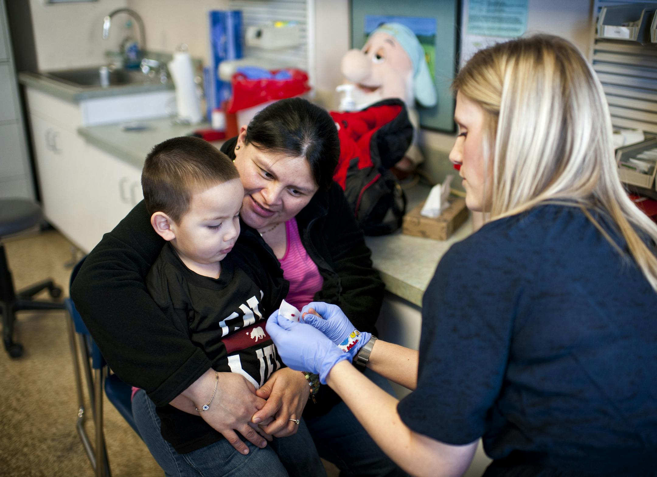 WIC nutrition educator Traci Rounds tested hemoglobin of client at WIC St. Paul office.