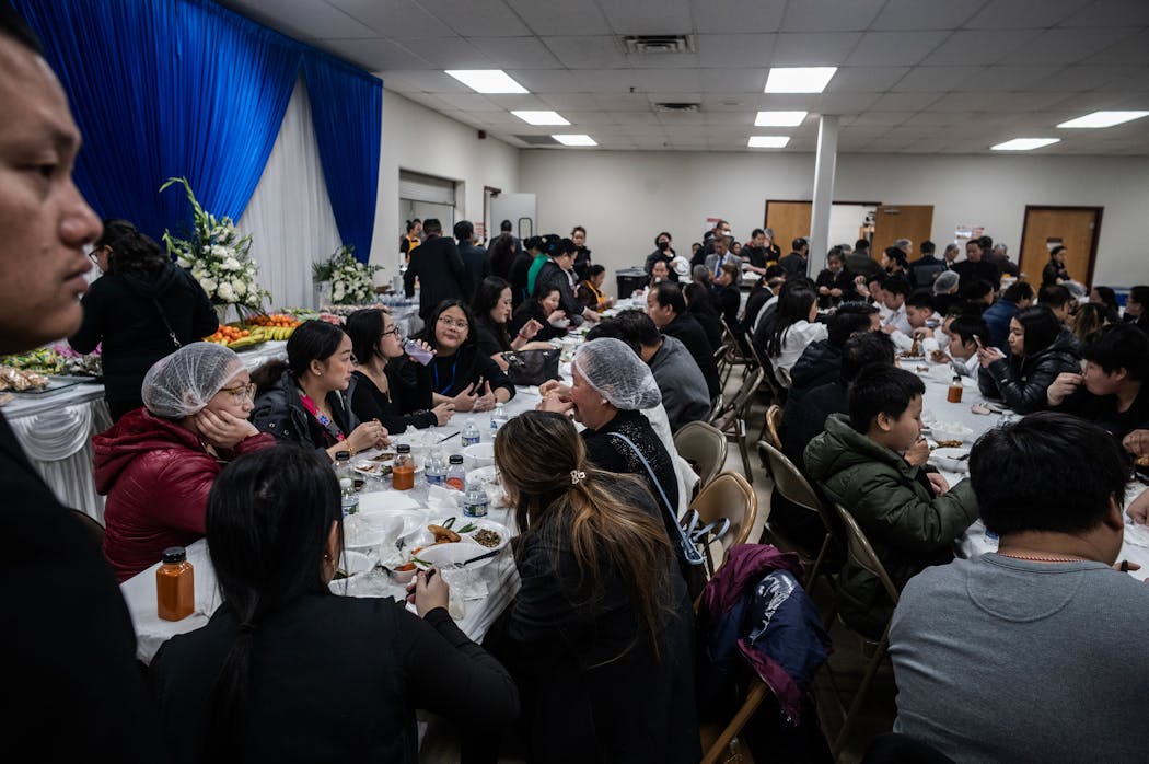 Mourners shared a communal meal in honor of Muaj Tshav Ntuj Vang, 4, at his funeral Saturday. 