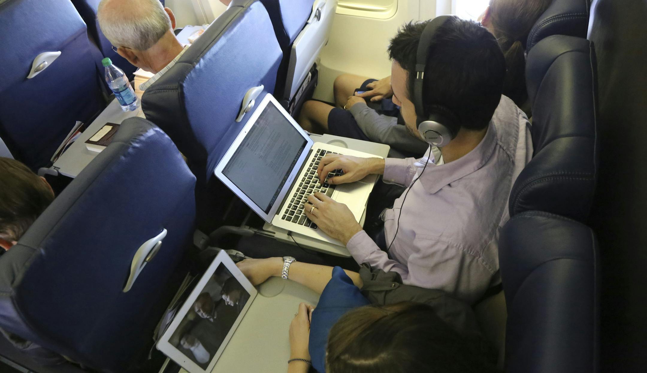 Travelers use a laptop and tablet aboard a Southwest Airlines flight in Baltimore, Aug. 31, 2013. This week, a Federal Aviation Administration advisory panel will meet to complete its recommendations to relax most of the guidelines restricting the use of electronic devices on airplanes. (Marty Katz/The New York Times)