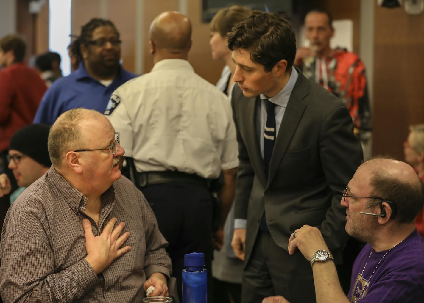 Minneapolis Mayor Jacob Frey chatted with Timothy J. Korsmoe, left, at the beginning of a community meeting about public safety on Wednesday.