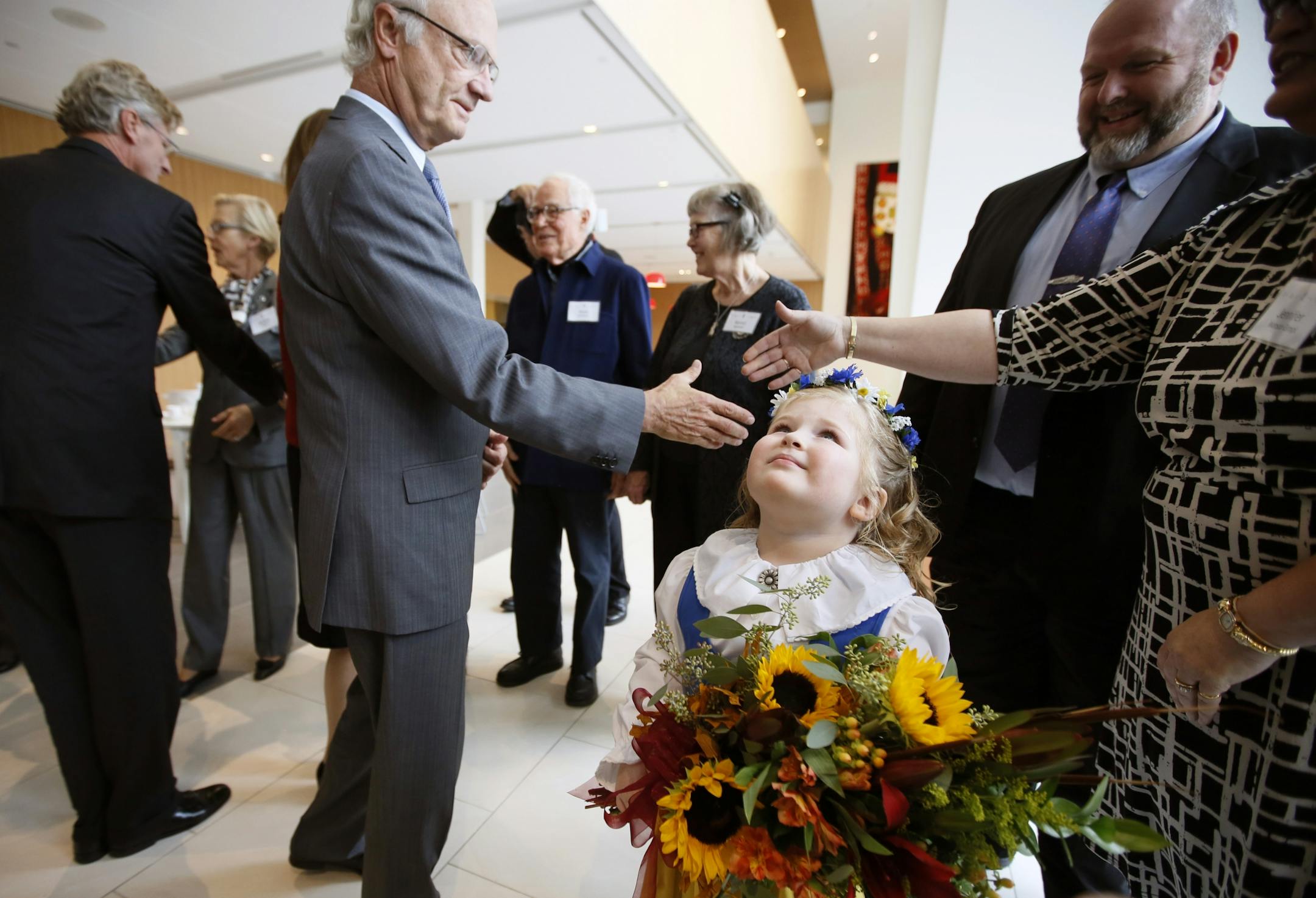 4-year-old Lily Monson-Gimpl of Falcon Heights waited to present flowers to Sweden's Queen Silvia and King Gustav, left, at the new Nelson Cultural Center.