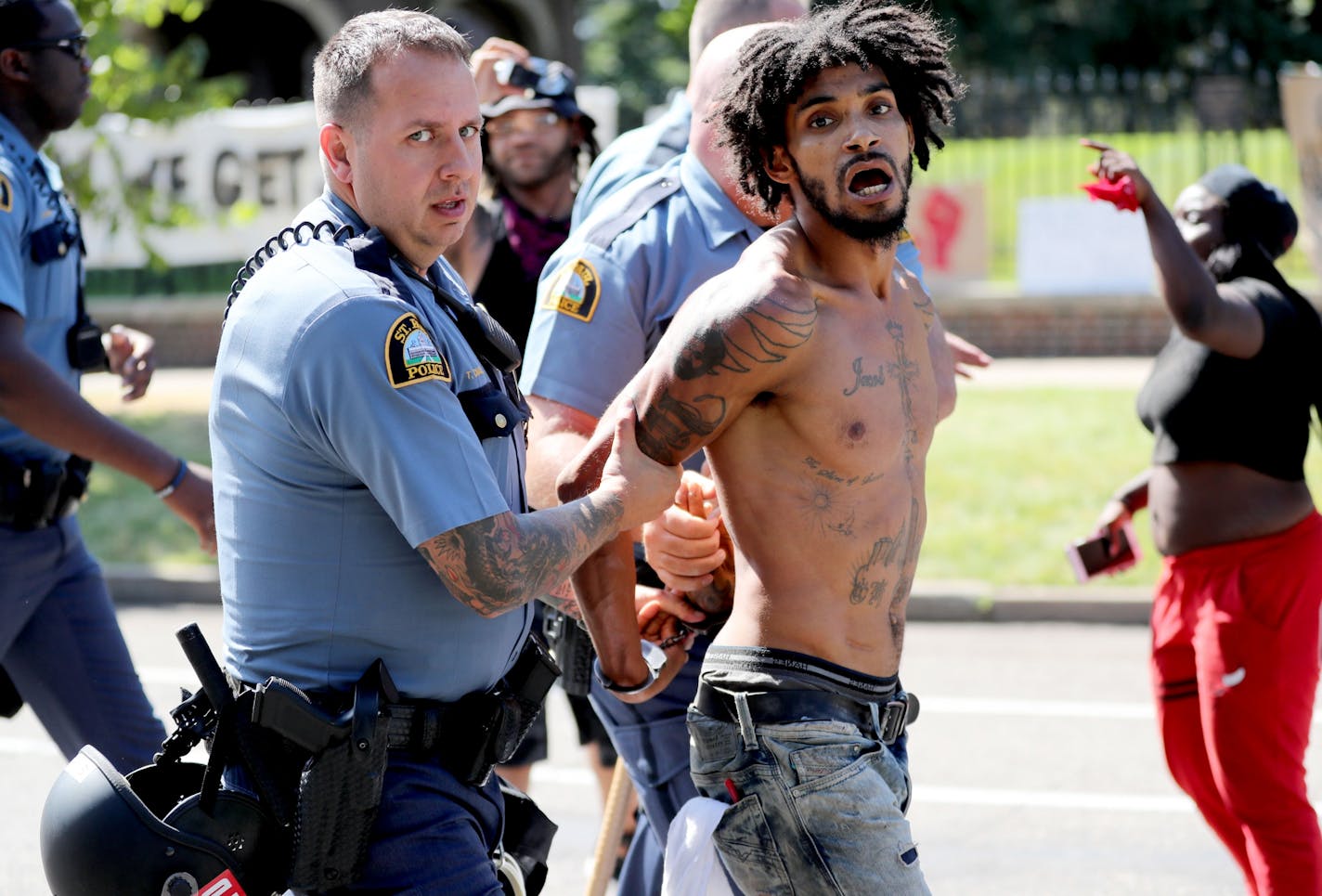 After St. Paul police officers moved in on protesters, one of the movement's leaders, Jacob Ladda, is taken away in handcuffs Tuesday, July 26, 2016, in front of the governor's residence on Summit Avenue.