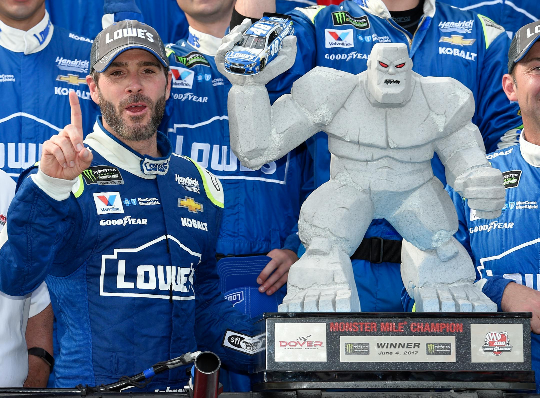 Jimmie Johnson, left, posed with the trophy in Victory Lane after he won a NASCAR Cup series auto race, Sunday, June 4, 2017, at Dover International Speedway in Dover, Del.