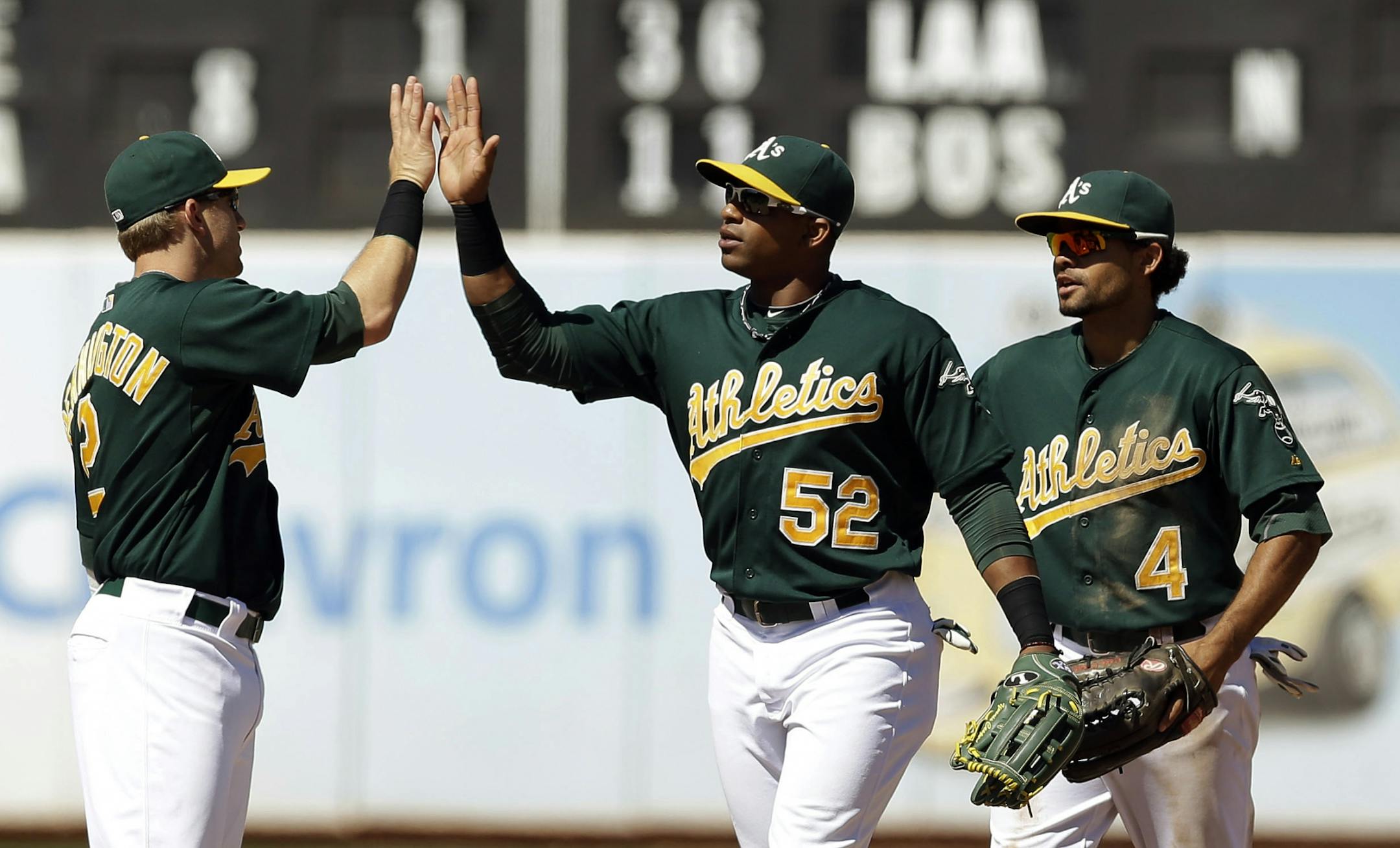 Oakland Athletics' Cliff Pennington, left, Yoenis Cespedes (52) and Coco Crisp (4) celebrate their 5-1 win over the Minnesota Twins during a baseball game, Wednesday, Aug. 22, 2012, in Oakland, Calif.
