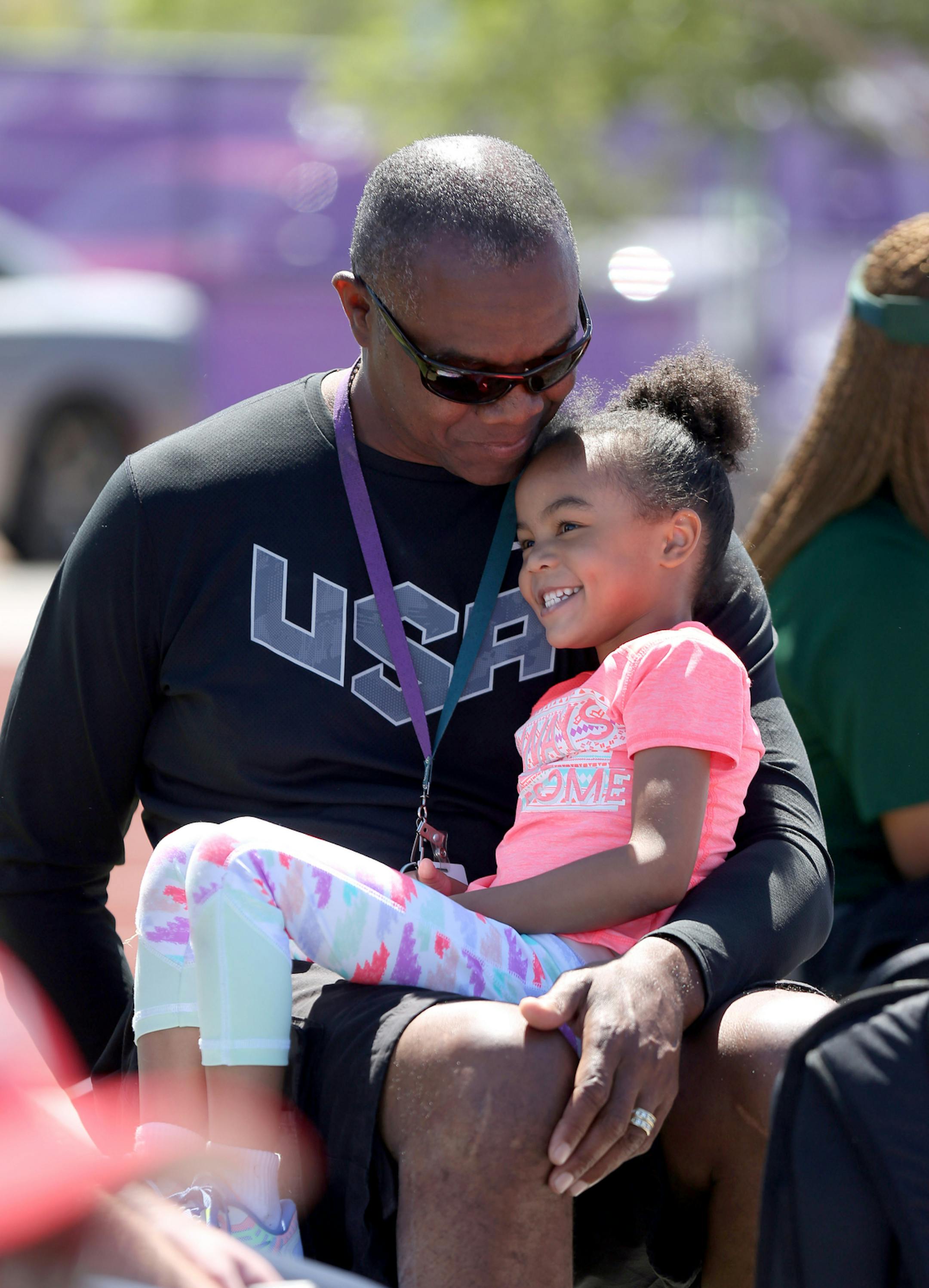 Former Minnesota Vikings quarterback Randall Cunningham holds his four-year-old daughter Sophia while coaching at a high school track meet Saturday, April 23, 2016, in Las Vegas. (Isaac Brekken for the StarTribune)