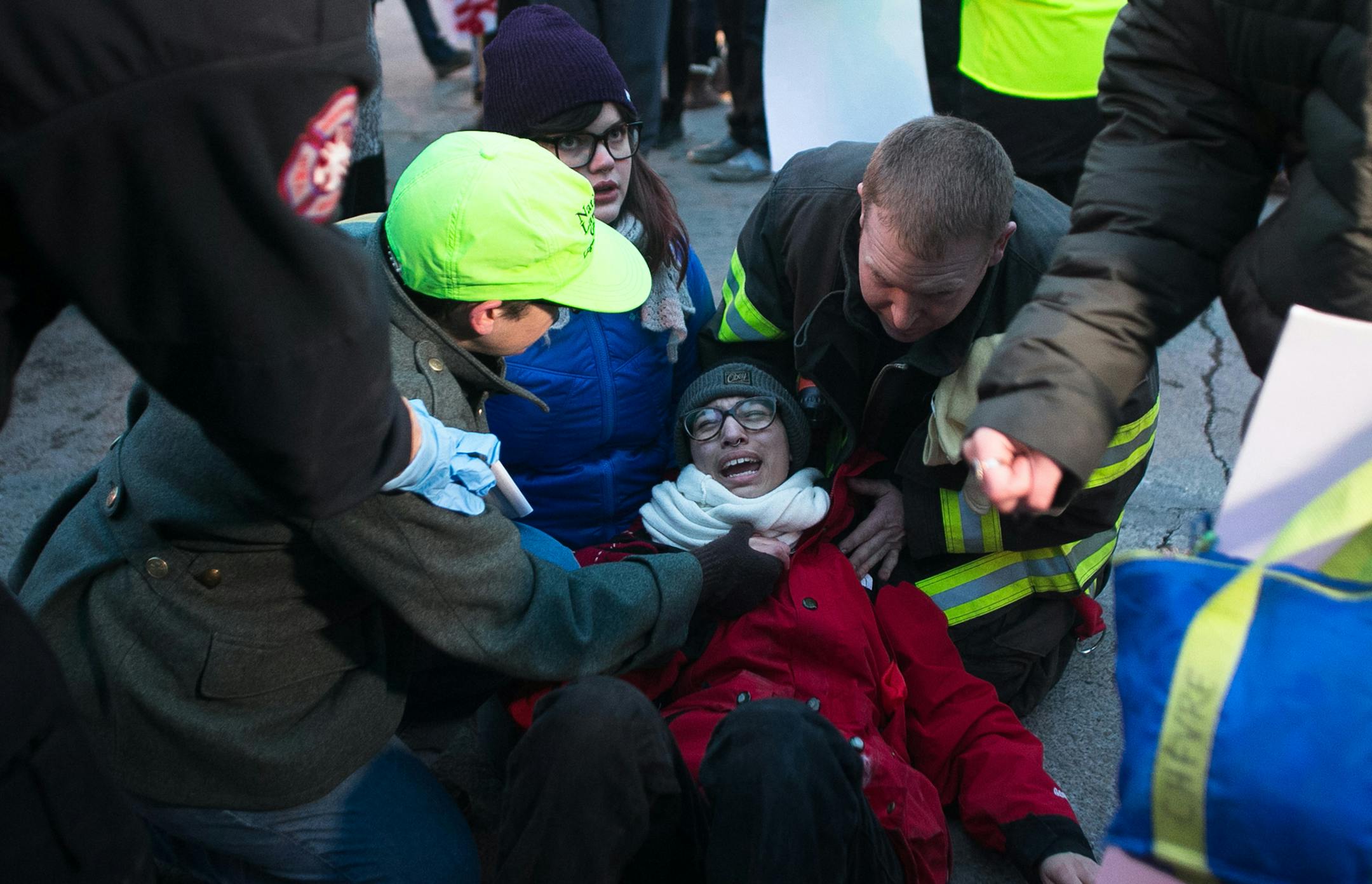 Demonstrators and first responders tend to the injuries of a woman who was hit by a car that plowed into a Ferguson rally in South Minneapolis after protesters blocked the intersection of Lake Street and Minnehaha Avenue on Tuesday, Nov. 25, 2014, in the wake of the grand jury decision not to indict officer Darren Wilson in the shooting death of Ferguson, Mo., teen Michael Brown. (Aaron Lavinsky/Minneapolis Star Tribune/TNS) ORG XMIT: 1160543 ORG XMIT: MIN1411251913471506