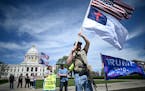 A protester waved flags in front of the Minnesota State Capitol Saturday afternoon.