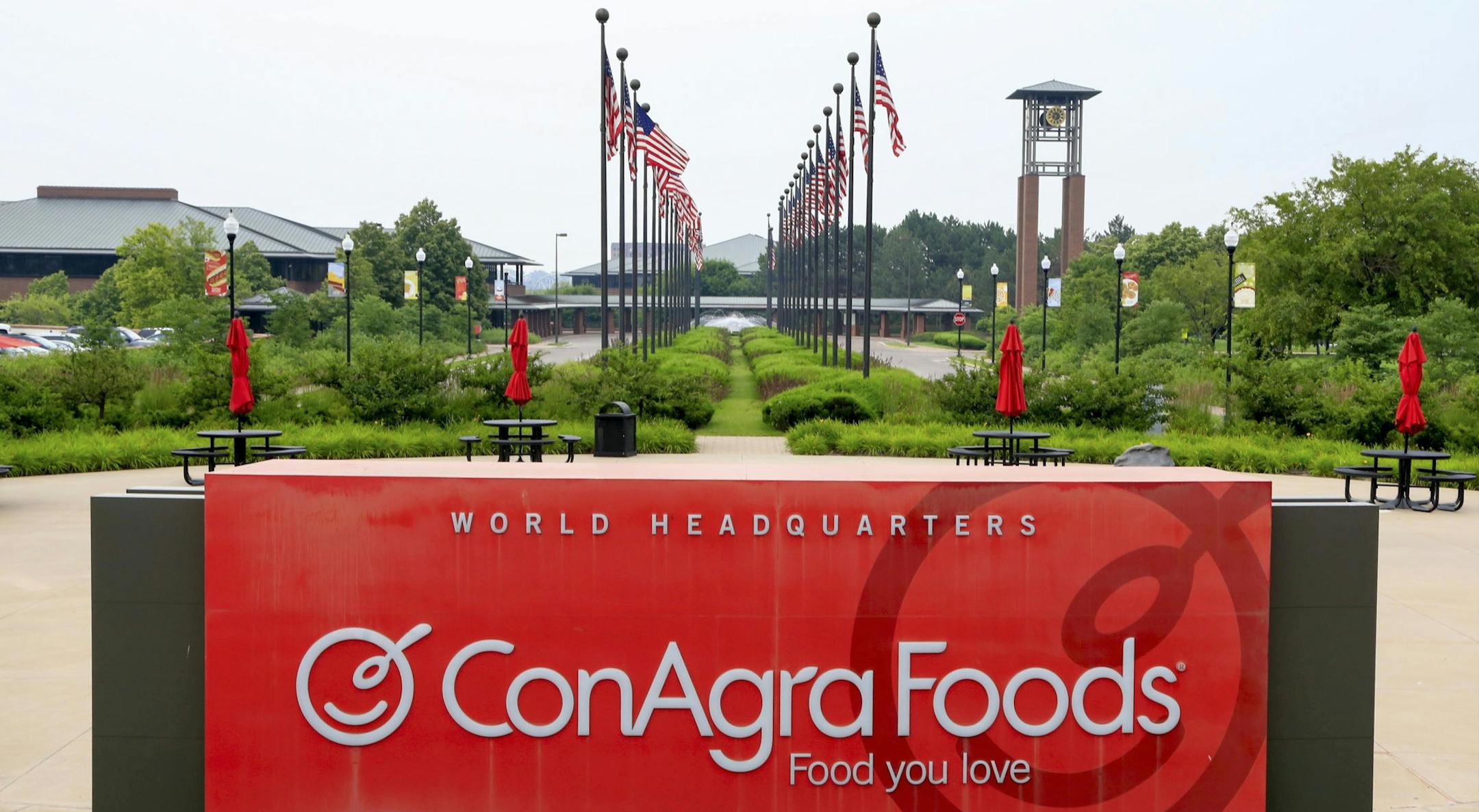 FILE - In this Tuesday, June 30, 2015, file photo, flags fly over ConAgra Foods world headquarters in Omaha, Neb. ConAgra Foods Inc. is selling its private label operations to TreeHouse Foods Inc. for about $2.7 billion as part its plan to focus more on name brands including Chef Boyardee and Slim Jim. The deal comes one month after ConAgra said it will cut 1,500 jobs, or about 30 percent of its office-based workforce, and move its headquarters to Chicago from Omaha, Nebraska. (AP Photo/Nati Har