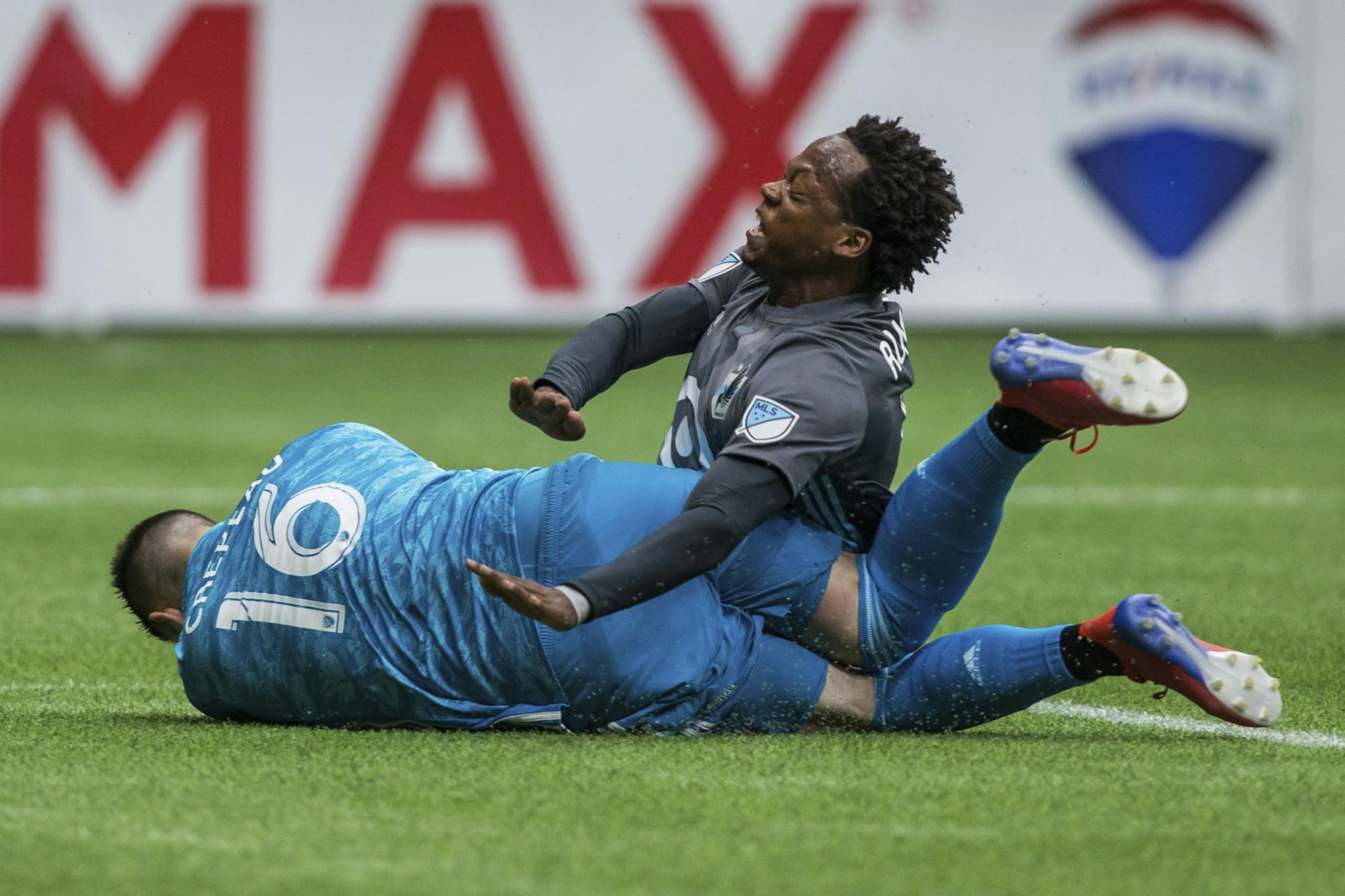Vancouver Whitecaps goalkeeper Maxime Crepeau (16) collides with Minnesota United's Romario Ibarra during the first half of an MLS soccer match Saturday, March 2, 2019, in Vancouver, British Columbia.