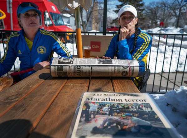Jody Nelson, left and Lisa Kresky-Griffin, looks over 10 year-year- old newspaper coverage of the Boston Marathon's bombing Sunday April, 2023 in Minn