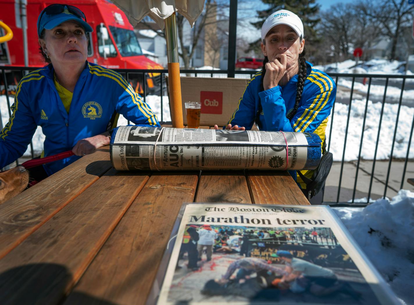 Jody Nelson, left and Lisa Kresky-Griffin, looks over 10 year-year- old newspaper coverage of the Boston Marathon's bombing Sunday April, 2023 in Minneapolis, Minn.