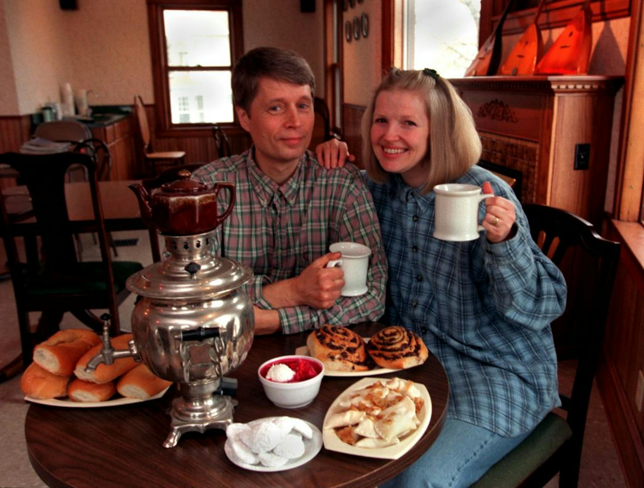 Russian Piroshki & Tea House. -- (Left to right) Nikolai and Linda Alenov are surrounded by piroshki, chocolate poppy rolls, borscht, pirogi with onion butter sauce, tea cakes and Black Russian Tea from the samovar.