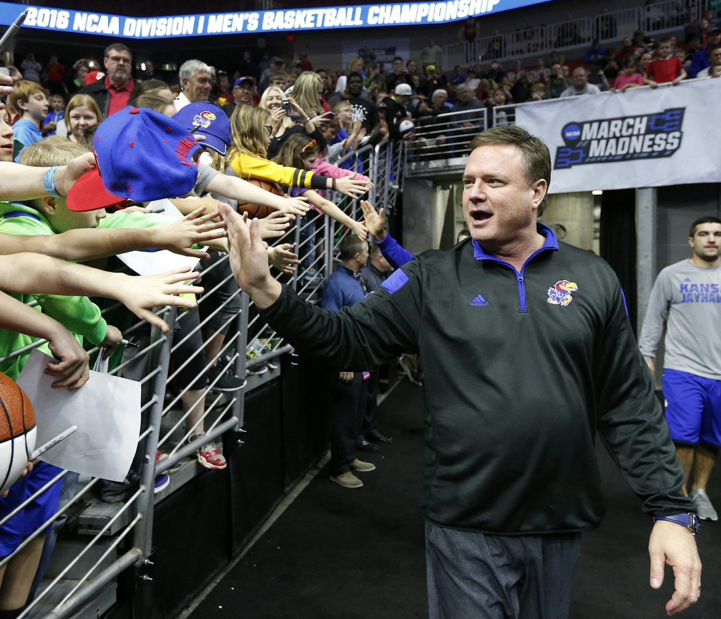 Kansas head coach Bill Self high-fives fans on his way to the court for a Jayhawks' practice session in 2016.