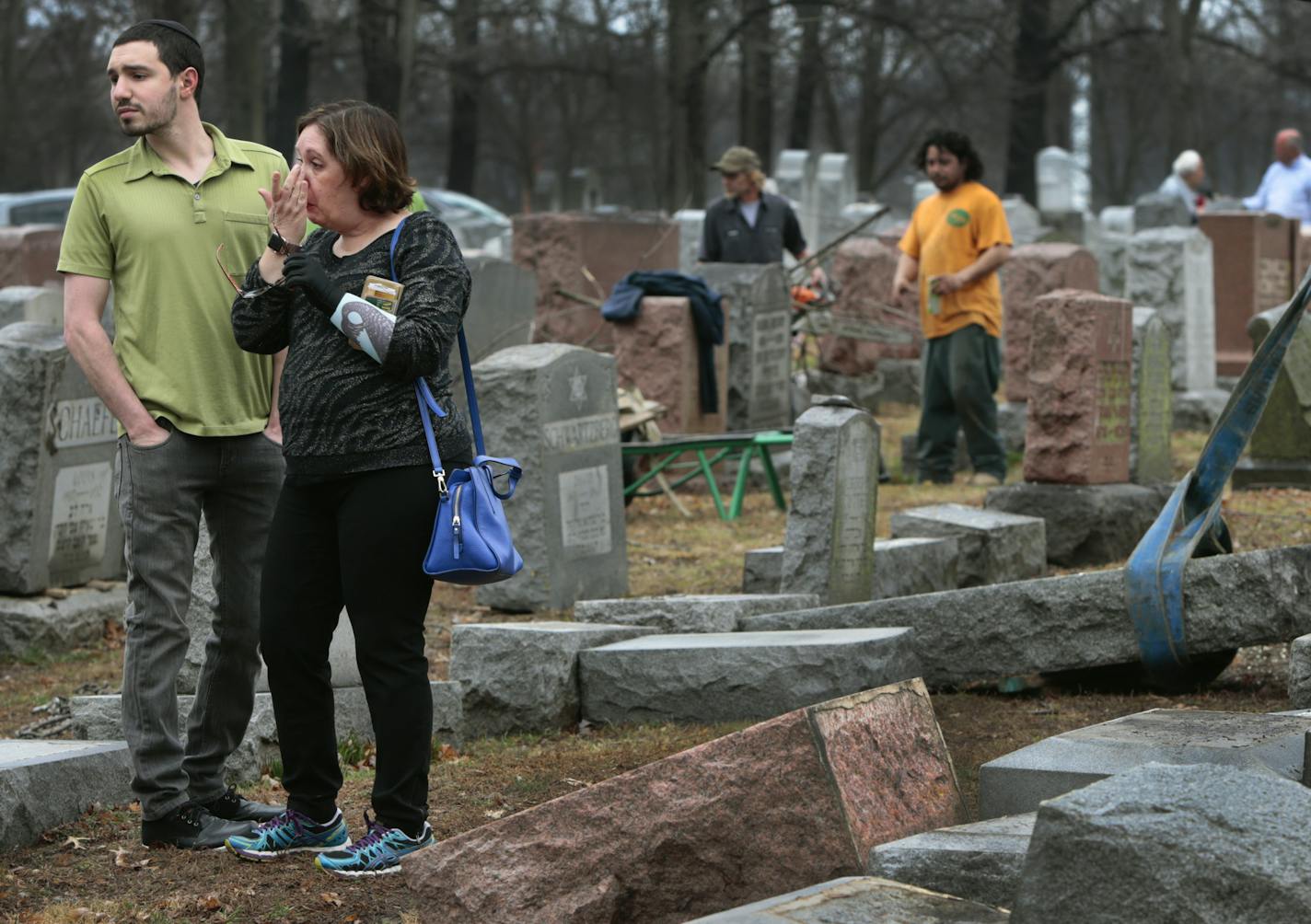 Sally Amon and her son Max Amon of Olivette, Mo., react as they saw toppled gravestone of her grandmother Anna Ida Hutkin at Chesed Shel Emeth Cemetery in University City, a suburb of St. Louis on Tuesday, Feb. 21, 2017. Vandals have damaged or tipped over as many as 200 headstones at the Jewish cemetery in suburban St. Louis, leaving the region's Jewish community shaken and anxious. (Robert Cohen/St. Louis Post-Dispatch via AP)