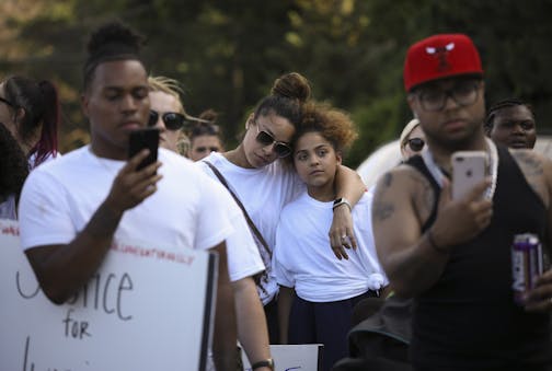 Before the Peace Walk began, people attending the rally listened as Thurman Blevins' cousin, Melinda Blevins talked about him. Another cousin, Rashaun Brown, left, and a nephew, DuPrece Slaughter, filmed her speaking with their phones.