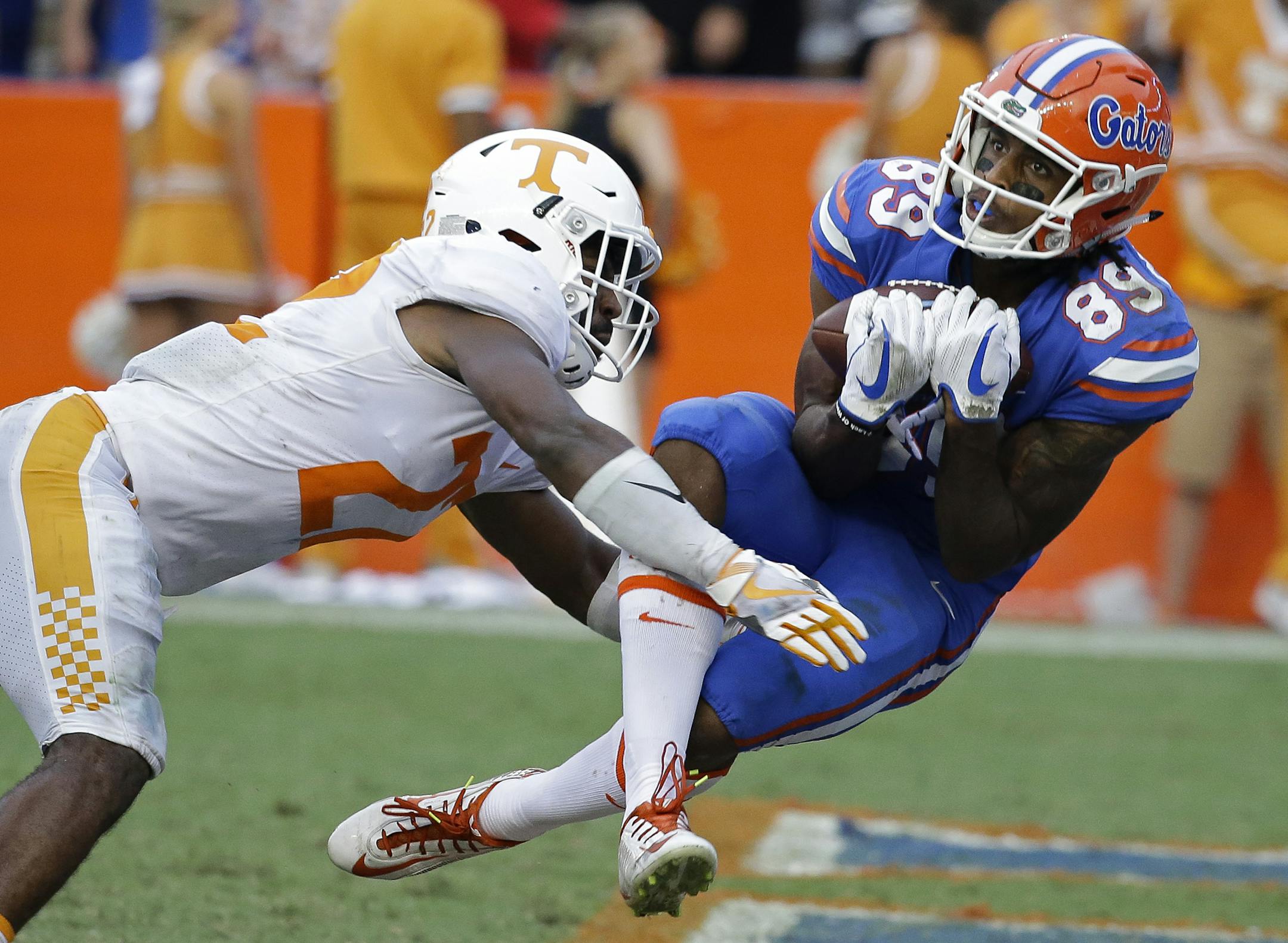 Florida wide receiver Tyrie Cleveland, right, catches the game winning 63-yard touchdown pass in front of Tennessee defensive back Micah Abernathy (22) as time expired in the fourth quarter of an NCAA college football game, Saturday, Sept. 16, 2017, in Gainesville, Fla. Florida won 26-20. (AP Photo/John Raoux)
