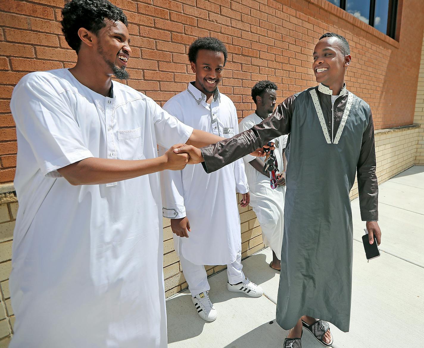 Mohamoud Ibrahim, right, a specialist in the Army Reserve, said goodbye to his friends after the Friday prayer at the Islamic Institute of Minnesota's mosque in Burnsville, MN, Friday, August 5, 2016. Ibrahim will leave for Wisconsin on Saturday for three weeks for Army training.