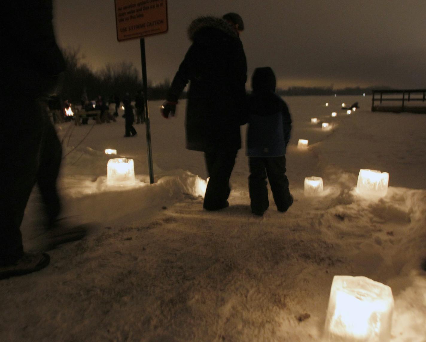 MARLIN LEVISON*mlevison@startribune.com GENERAL INFORMATION New Years eve celebration at Fort Snellng State Park with skating by a wood fire, hot chocolate and cider and a walk through cadle lit paths. IN THIS PHOTO: ] A family walked the lighted path towards the skating rink. Fort Snelling State Park