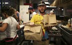 Jeff O'Neill carried three orders for delivery out of the kitchen at Taco Cat in the Midtown Global Market in Minneapolis Thursday night. ] JEFF WHEEL