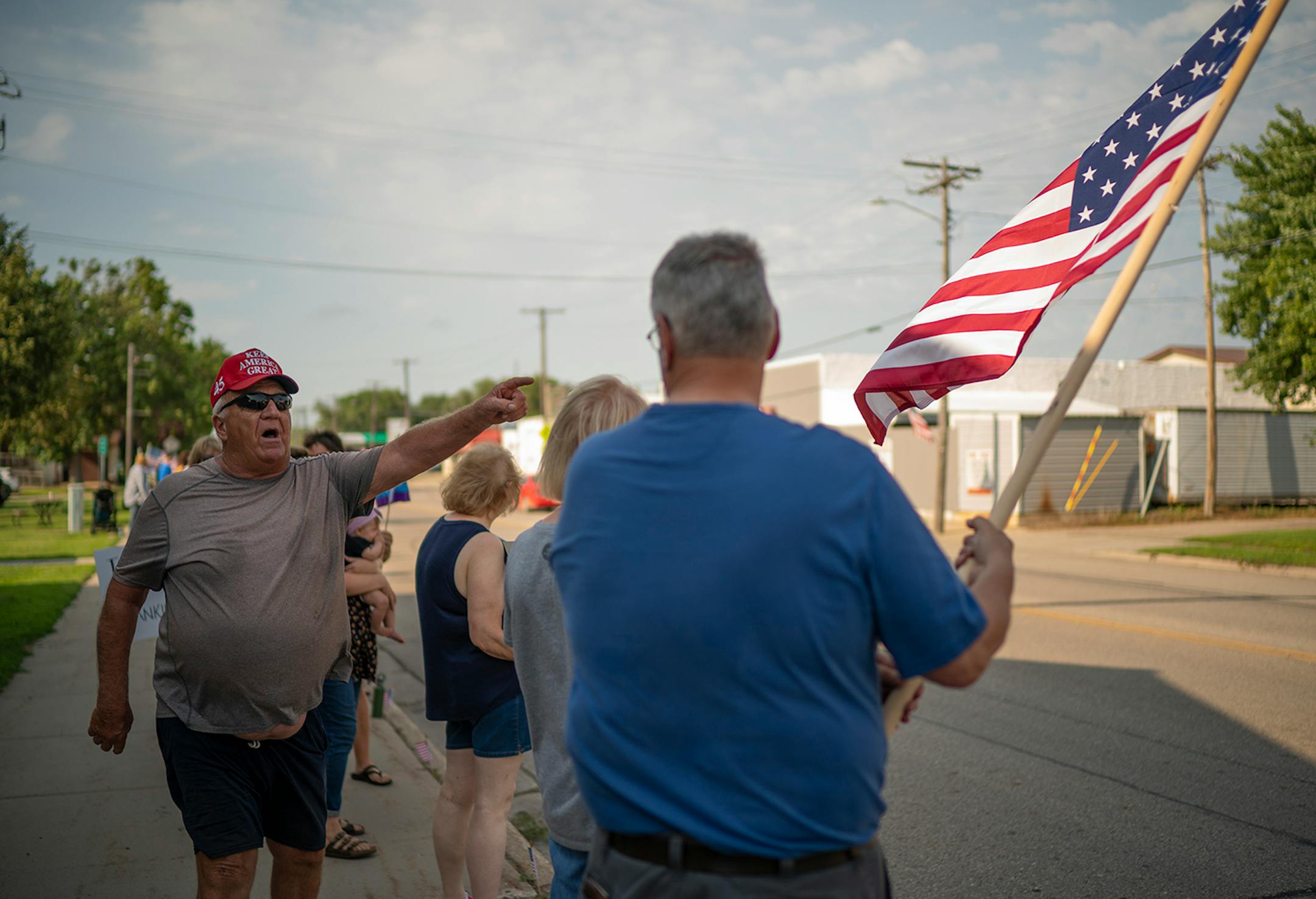 Dan Lohse, who was with other pro-Trump demonstrators at the other end of the block, left them to attempt to provoke Kevin Wilkening, who was holding an American flag at right with the social justice supporters.