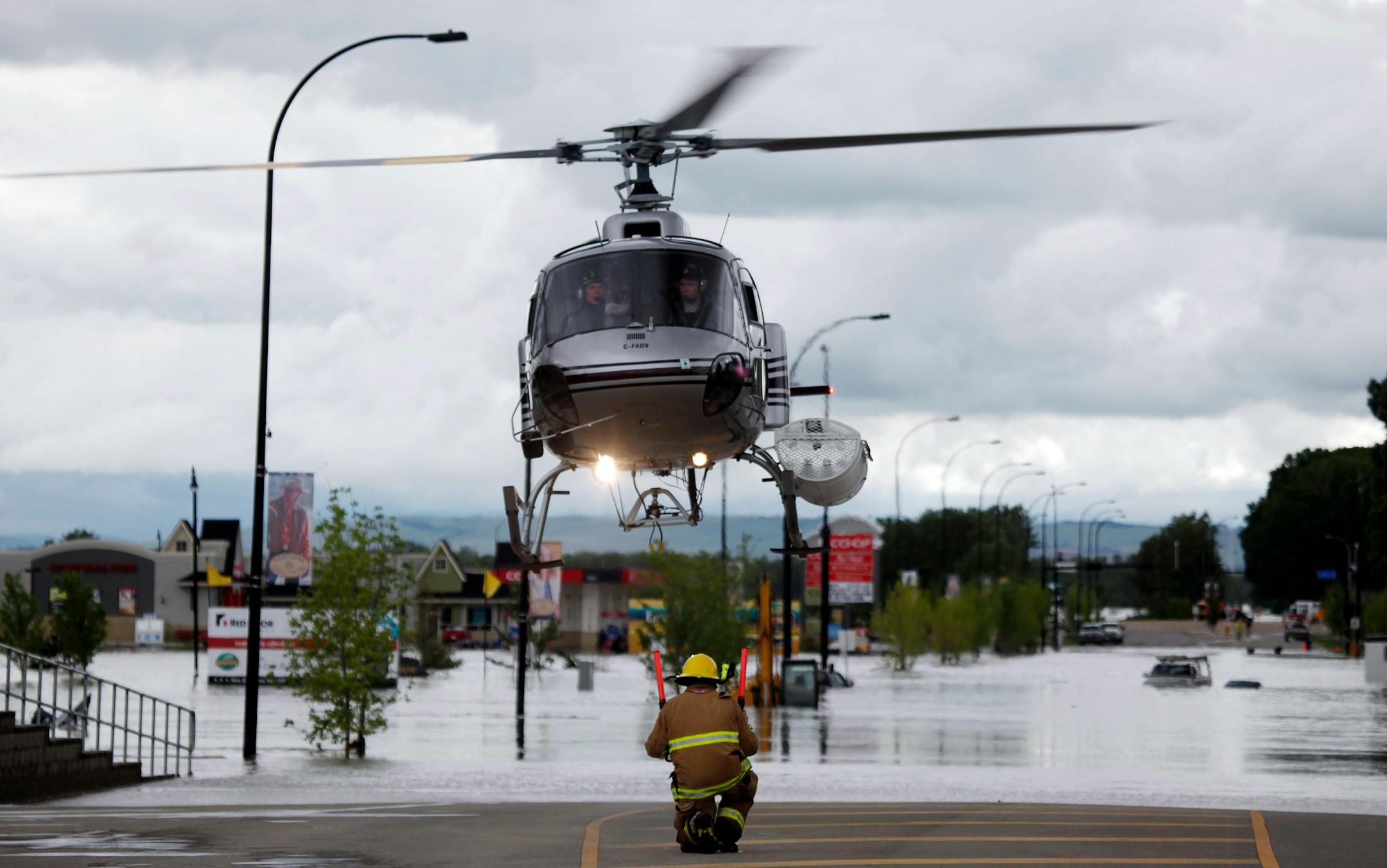 A helicopter carrying evacuated residents lands on a road in High River, Alta., Thursday.
