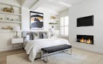Black-and-white artwork as well as a accent bench help add a sense of glam and contrast to this master bedroom.