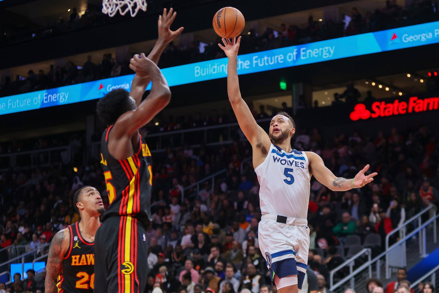 Minnesota Timberwolves forward Kyle Anderson, right, shoots over Atlanta Hawks center Clint Capela, left, in the second half of an NBA basketball game, Monday, March 13, 2023, in Atlanta. (AP Photo/Brett Davis)