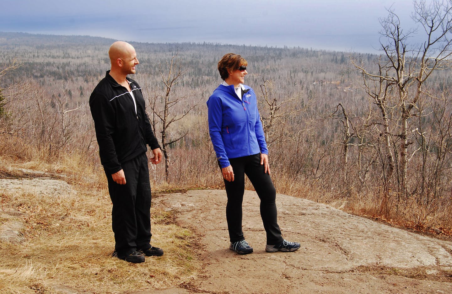 Fitness program director Leif Anderson and Lori Schaefer hike along Oberg Mountain overlooking Lake Superior, just as they did before Schaefer lost weight. Photo by Lori Leifon?