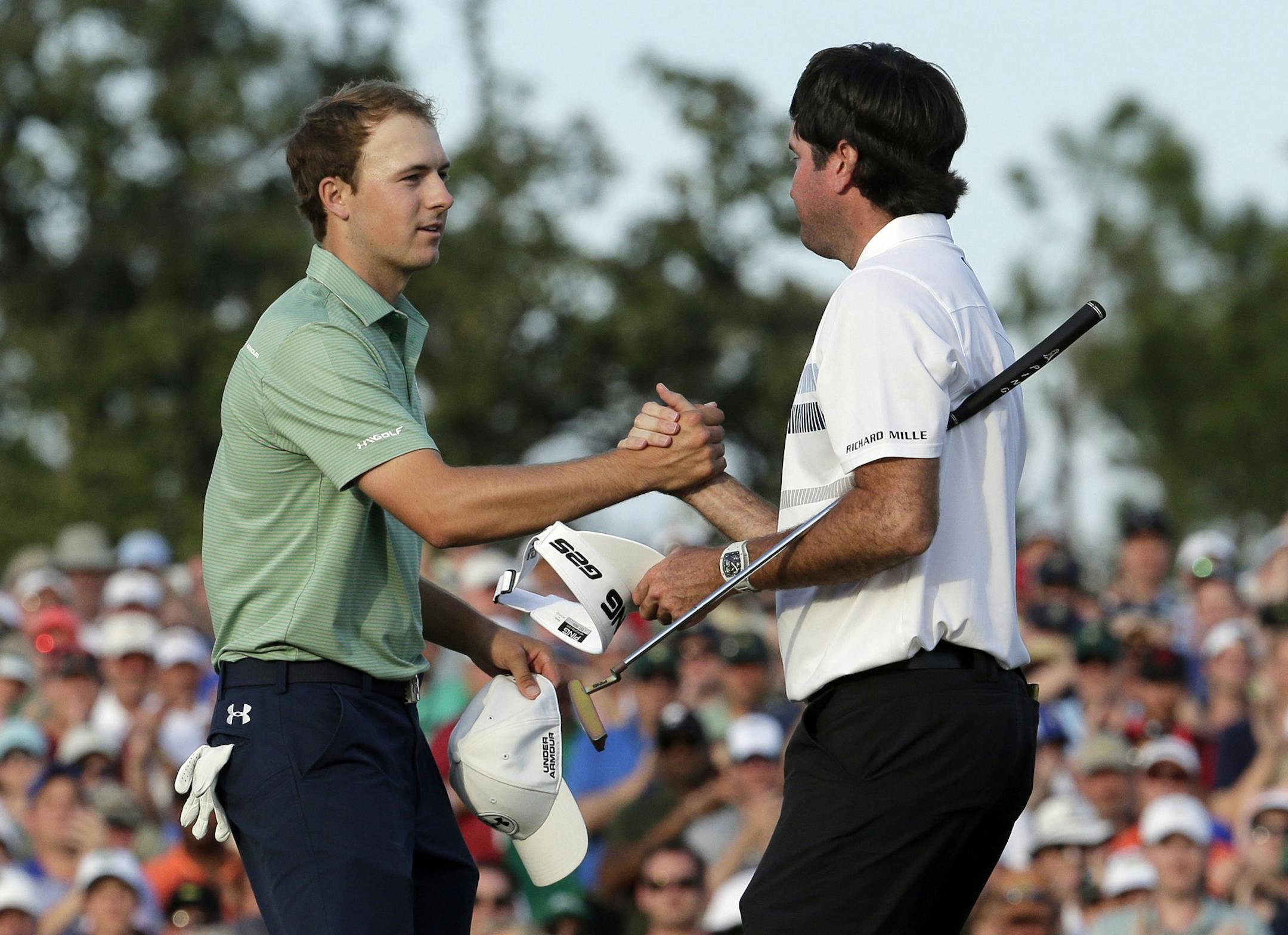 Bubba Watson, right, shakes hands with Jordan Spieth after winning the Masters golf tournament Sunday, April 13, 2014, in Augusta, Ga. (AP Photo/Charlie Riedel)