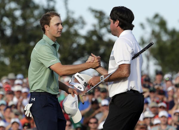 Bubba Watson, right, shakes hands with Jordan Spieth after winning the Masters golf tournament Sunday, April 13, 2014, in Augusta, Ga. (AP Photo/Charl