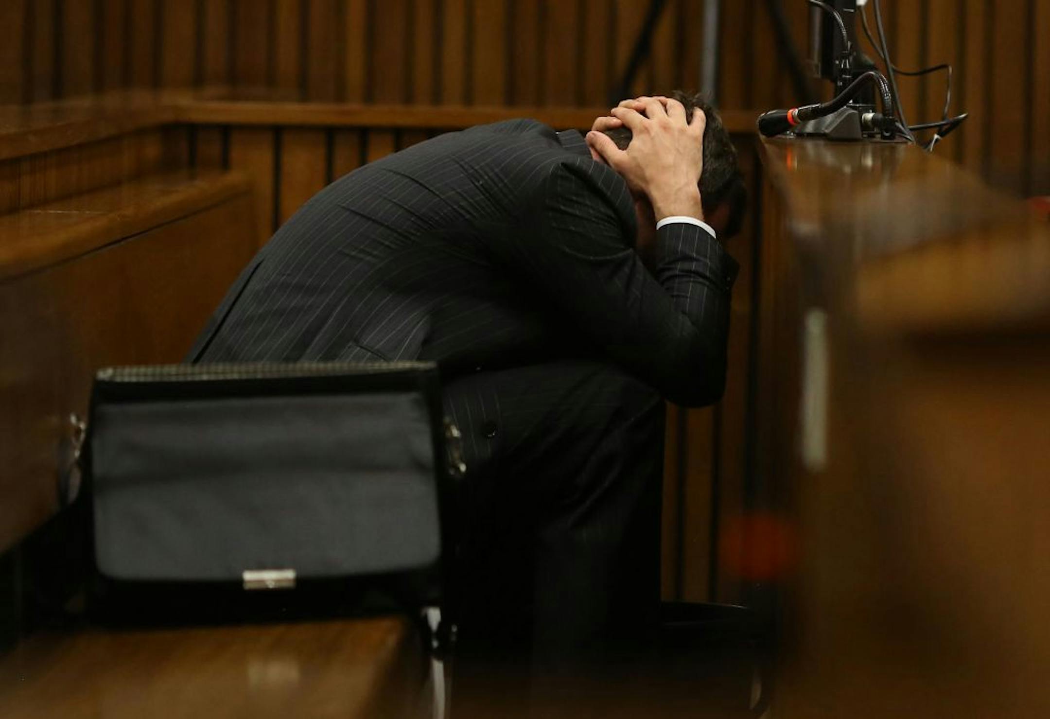 Oscar Pistorius buries his head in his hands covers his head as he listens to cross questioning about the events surrounding the shooting death of his girlfriend Reeva Steenkamp, in his second week in court during his trial in Pretoria, South Africa, Monday, March 10, 2014.
