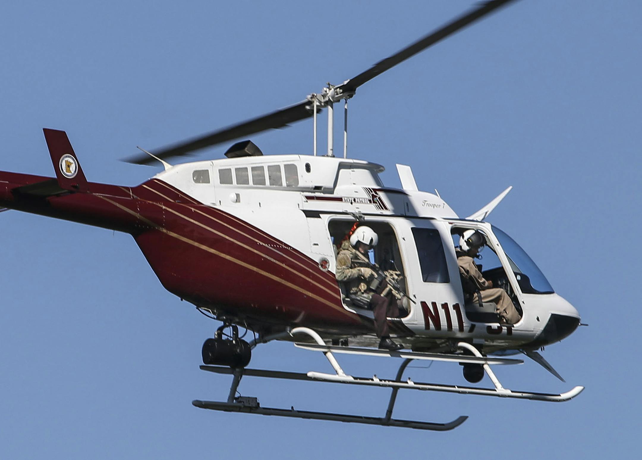 A Minnesota State Patrol helicopter patrols the woods around Anoka County-Blaine Airport searching for fugitive Lyle "Ty" Hoffman, Tuesday, Sept. 2, 2014, in Blaine, Minn. All gates to the airport were closed as authorities looked for Hoffman, accused of killing his ex-boyfriend last month. (AP Photo/The Star Tribune, David Joles) MANDATORY CREDIT; ST. PAUL PIONEER PRESS OUT; MAGS OUT; TWIN CITIES LOCAL TELEVISION OUT ORG XMIT: MIN2014090217104742