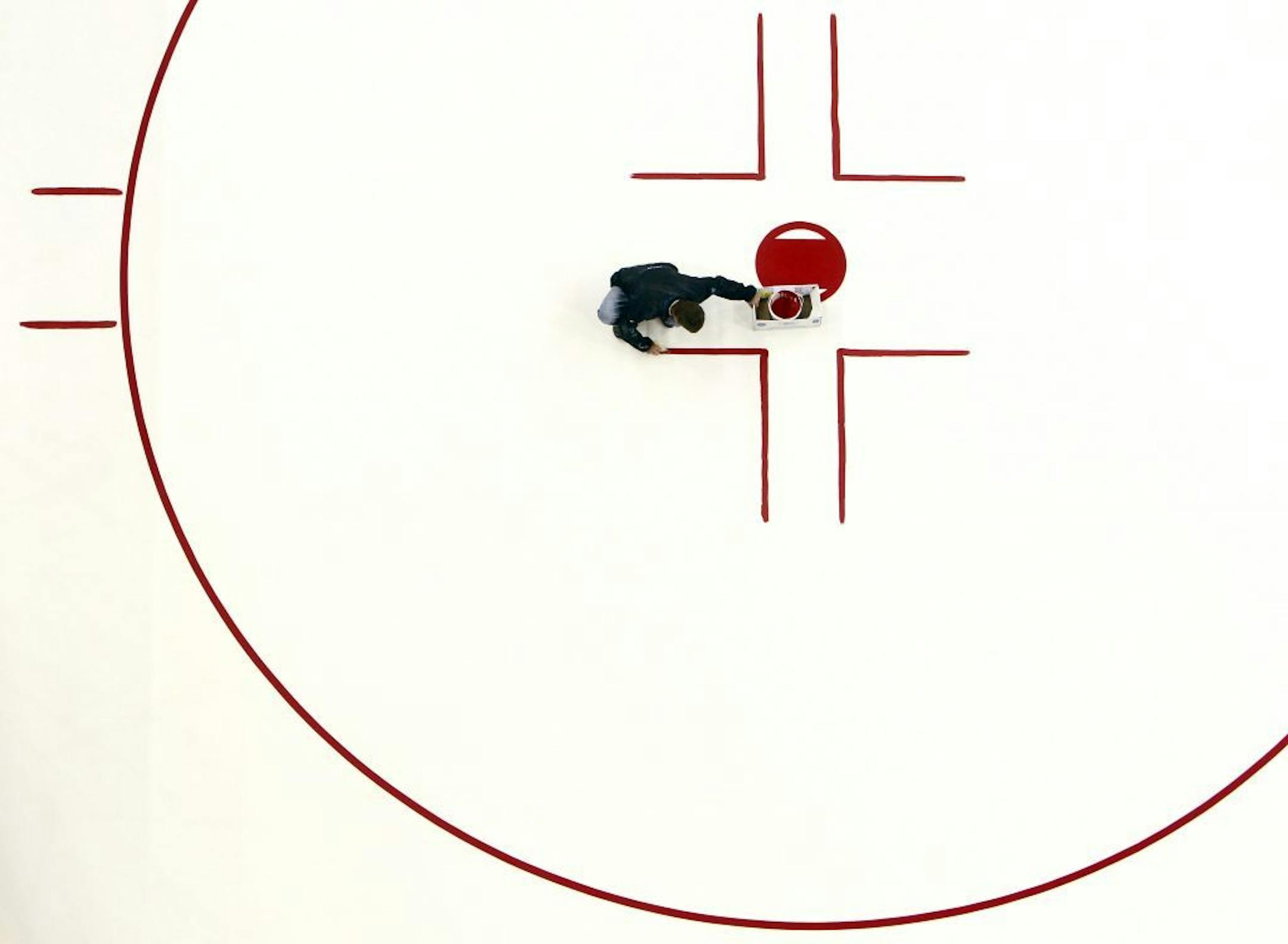 Jason Mulholland paints red hash marks at the Tampa Bay Times Forum as the NHL hockey lockout continues.