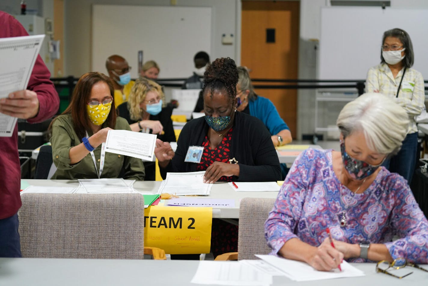 Workers recount election ballots by hand in Gwinnett County, Georgia on Friday, Nov. 13, 2020. President Donald Trump's legal team said Saturday that his campaign has requested a recount of votes in the Georgia presidential race after results showed Democrat Joe Biden winning the state.