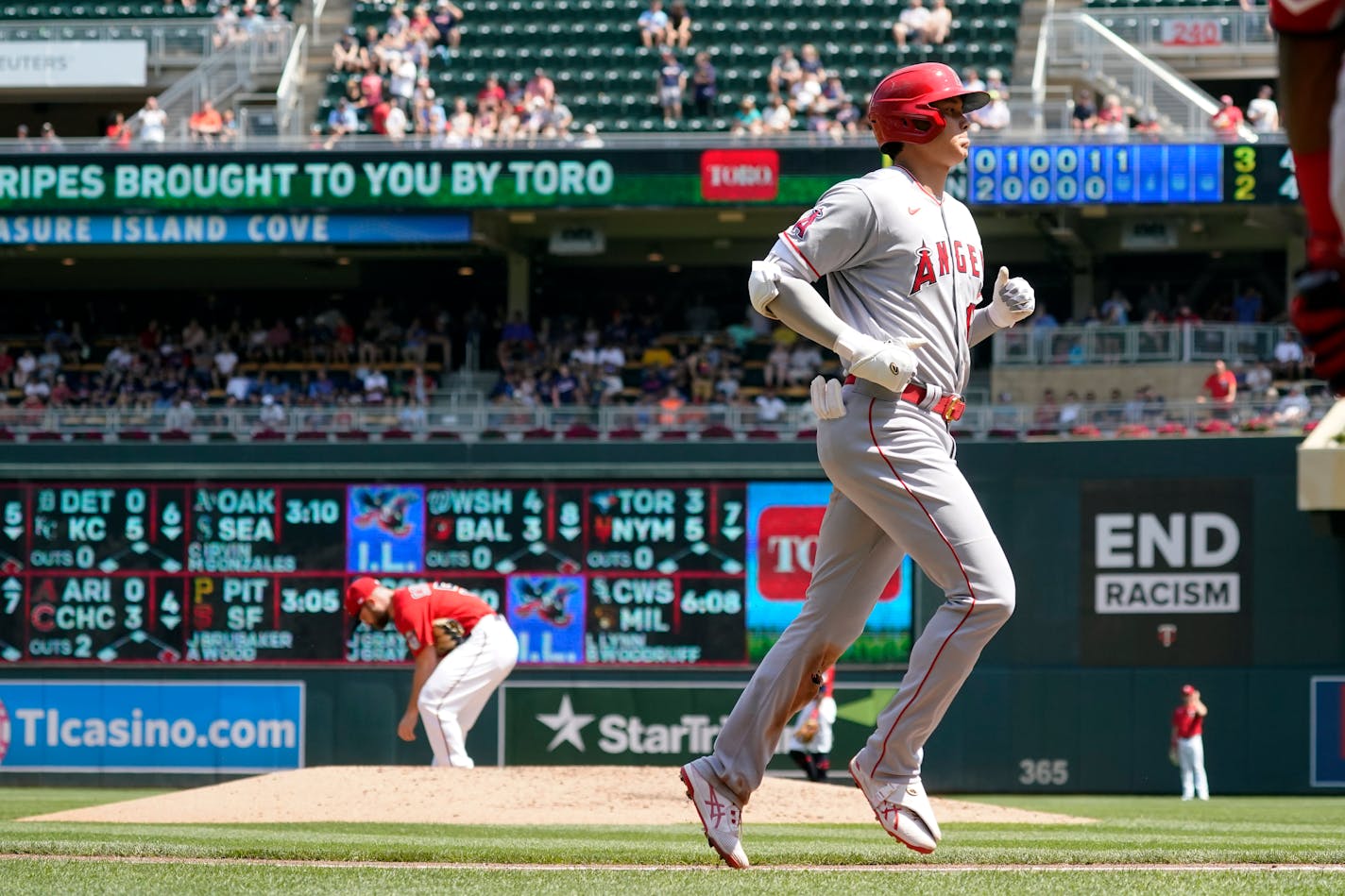 Los Angeles Angels' Shohei Ohtani jogs home after his solo home run off Minnesota Twins pitcher Danny Coulombe, left background, in the sixth inning of a baseball game, Sunday, July 25, 2021, in Minneapolis. The Angels won 6-2. (AP Photo/Jim Mone)