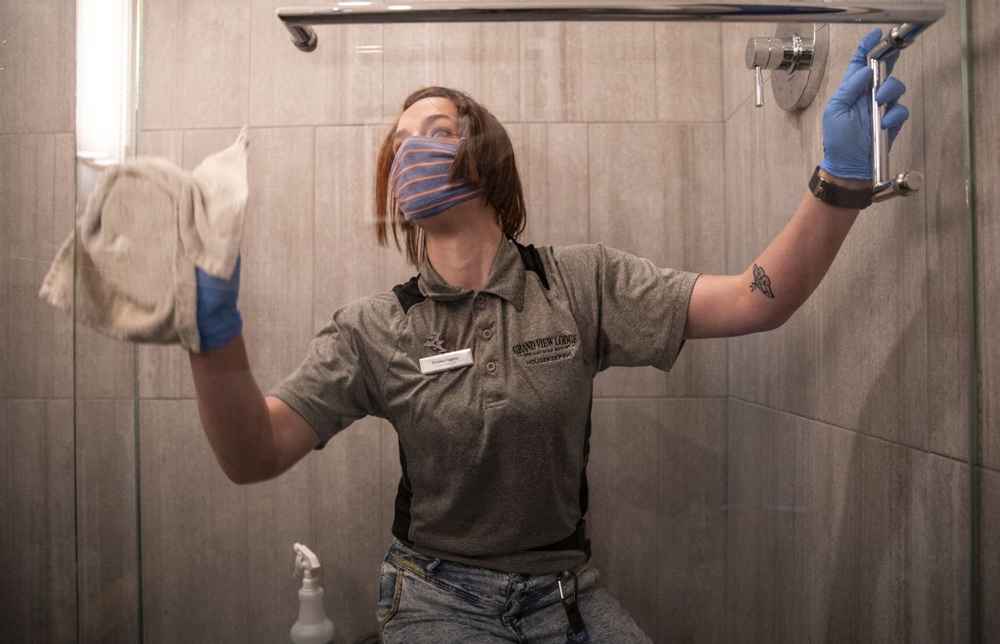 Brianna Engels, a housekeeping supervisor at the Grand View Lodge hotel, cleaned a shower in a room as part of the resort's efforts to reclean and disinfect before guests are allowed to return.