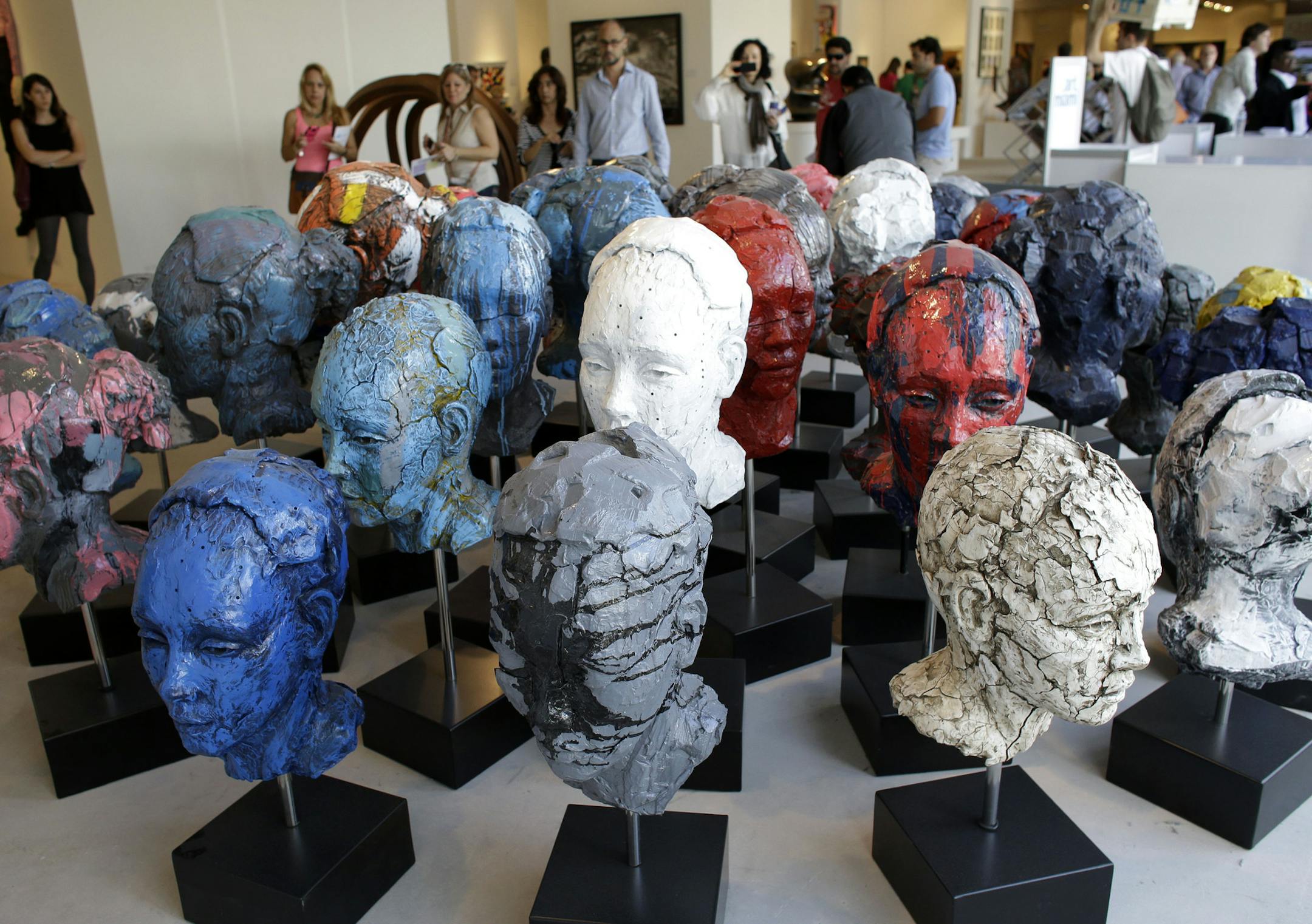 An installation of 40 heads made of cast resin by artist Lionel Smit titled "Accumulation of Disorder" is displayed at Art Miami, Sunday, Dec. 8, 2013, in the Design District neighborhood of Miami. Art Miami is one of numerous satellite fairs that run in conjunction with Art Basel in Miami Beach. (AP Photo/Lynne Sladky)