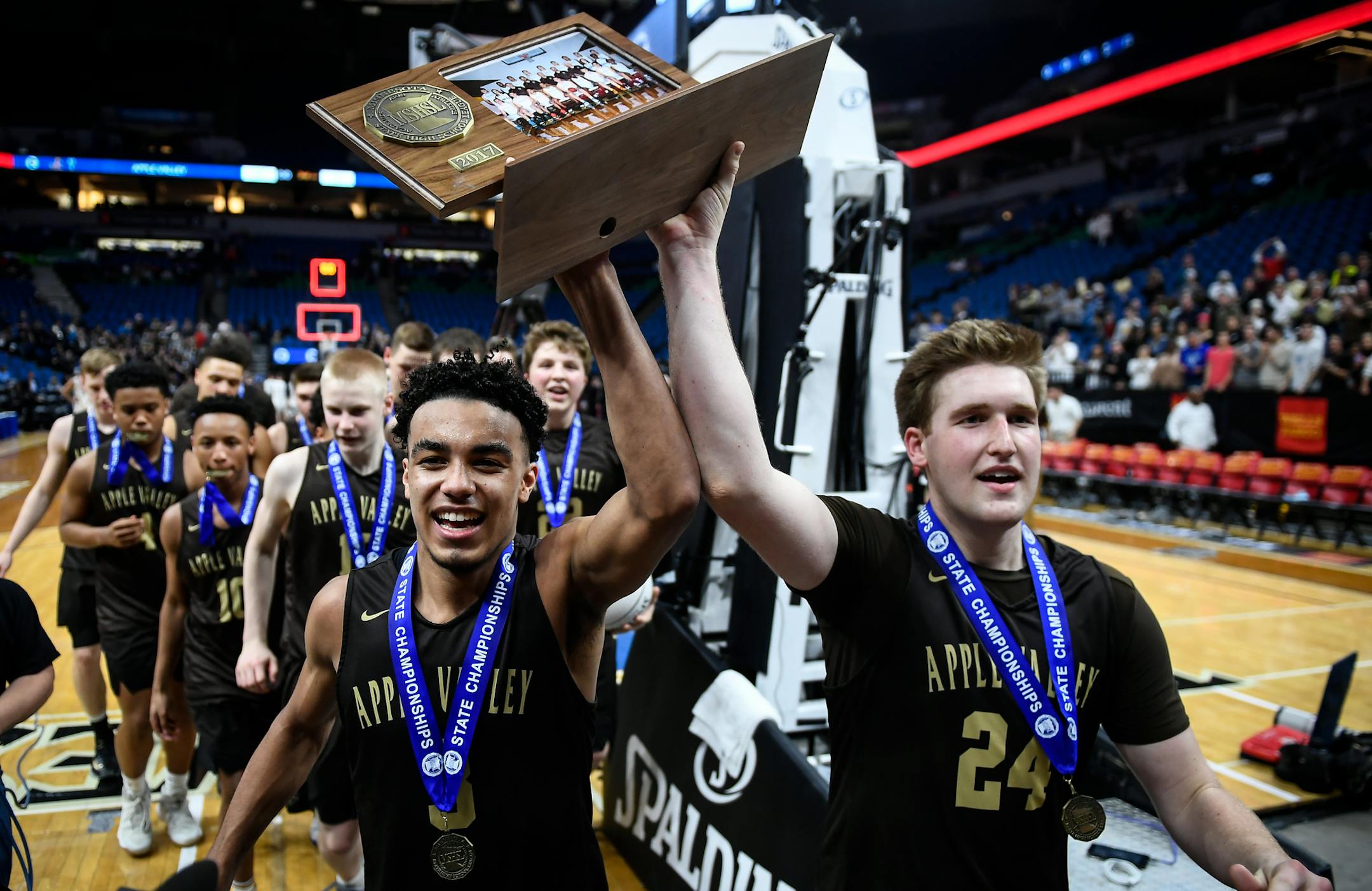 Apple Valley guard Tre Jones (3) and forward Mason Morse (24) marched their Class 4A boys' basketball championship trophy.