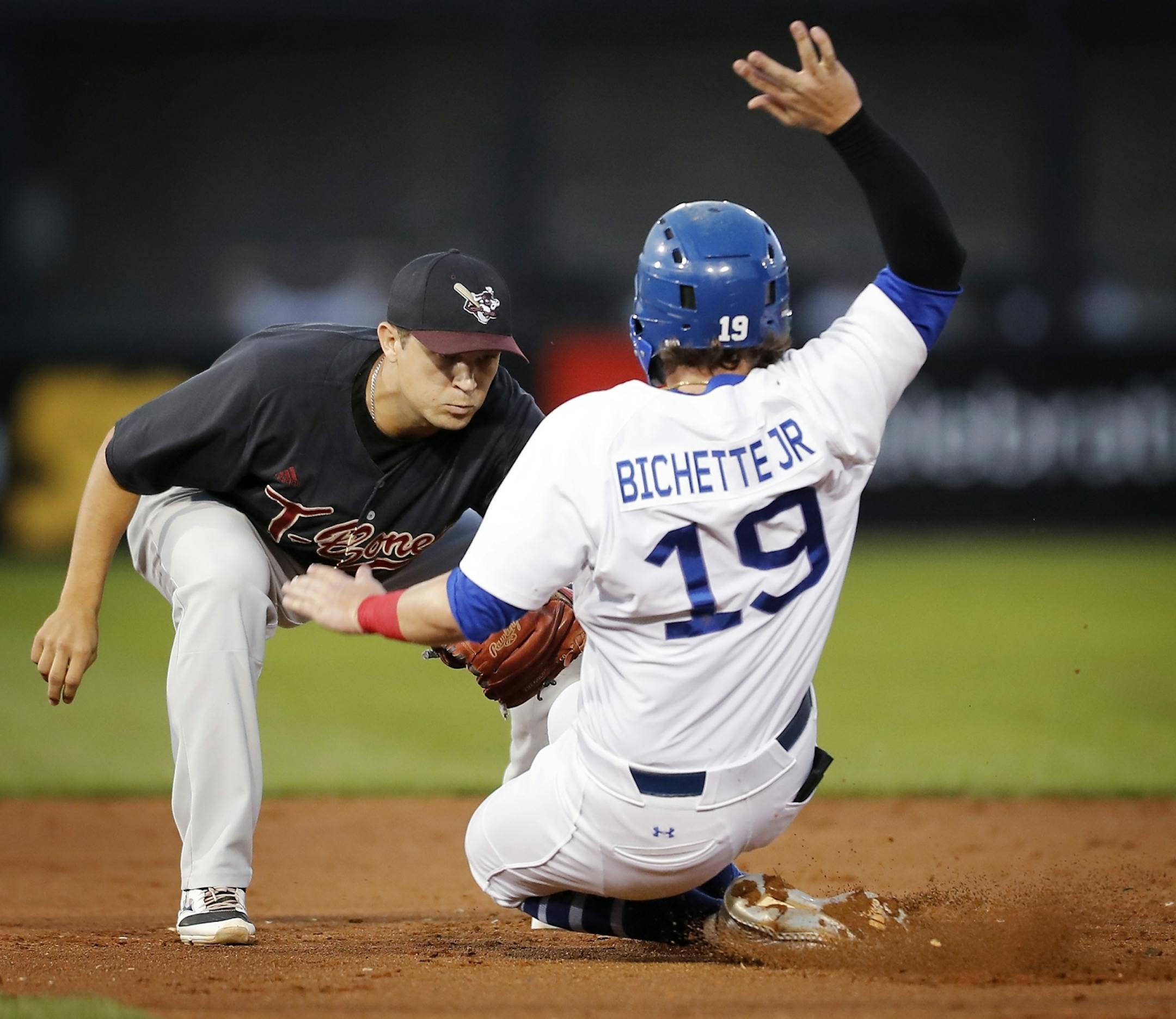 Saint Paul Saints third baseman Dante Bichette Jr. is tagged out at second base by Kansas City's Anthony Phillips.