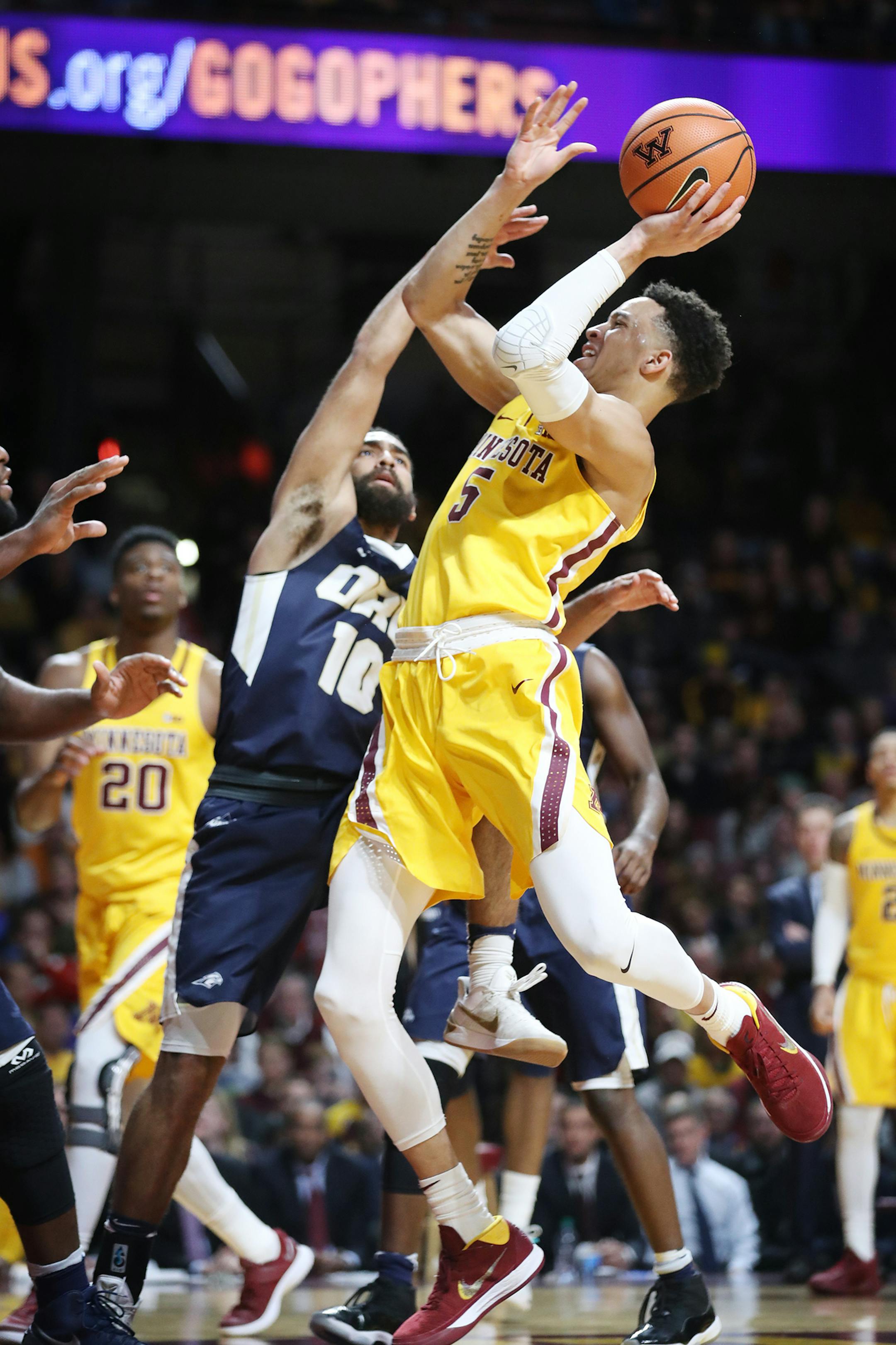 Amir Coffey (5) of the Minnesota Golden Gophers shoots as Sam Kearns (10) of the Oral Roberts Golden Eagles defends during the second half. ] LEILA NAVIDI ï leila.navidi@startribune.com BACKGROUND INFORMATION: Minnesota Golden Gophers play against the Oral Roberts Golden Eagles at Williams Arena in Minneapolis on Thursday, December 21, 2017. The Minnesota Golden Gophers won 77-63.