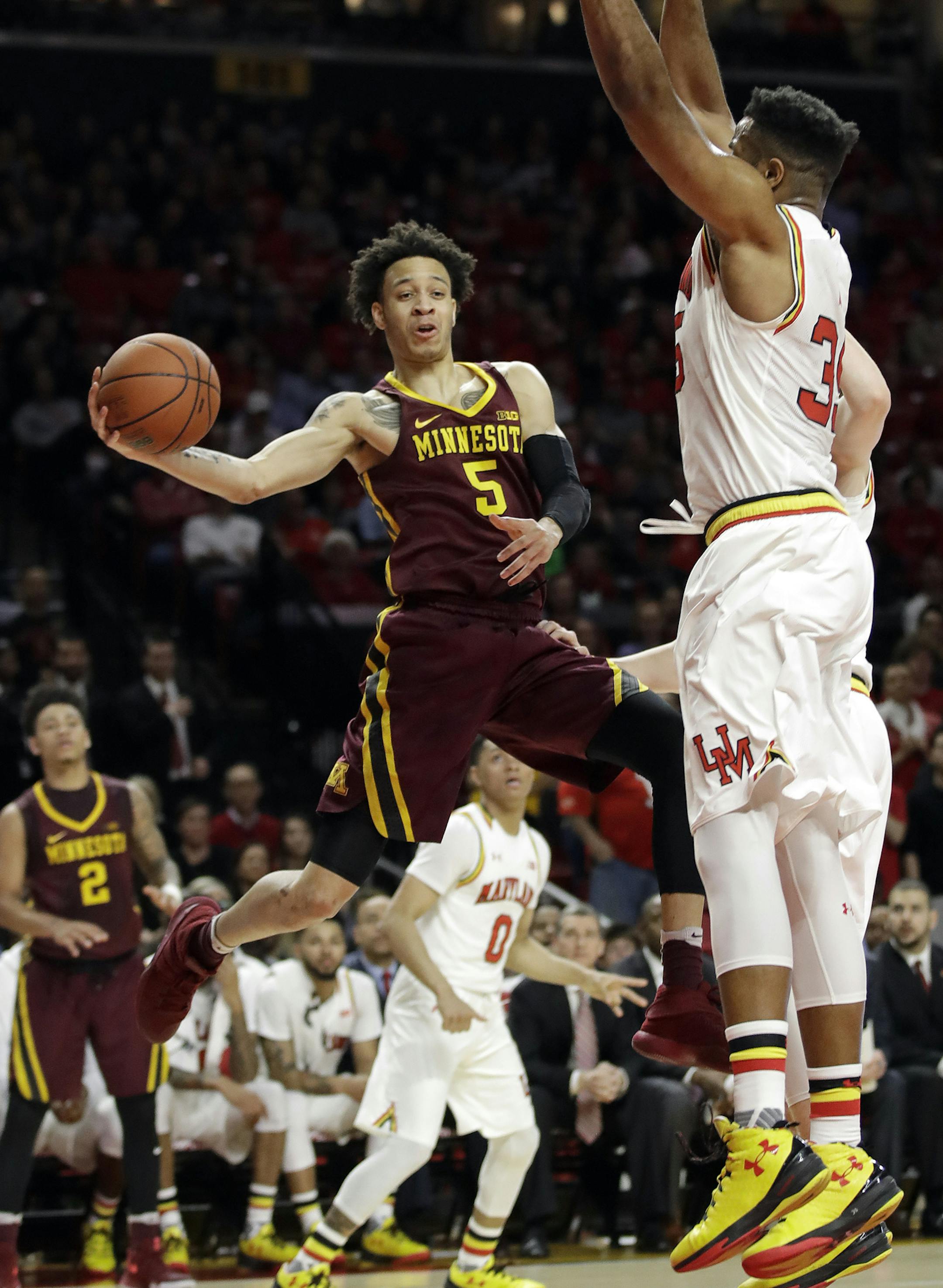 Minnesota guard Amir Coffey (5) passes the ball around Maryland forward Damonte Dodd during the first half of an NCAA college basketball game, Wednesday, Feb. 22, 2017, in College Park, Md. (AP Photo/Patrick Semansky)