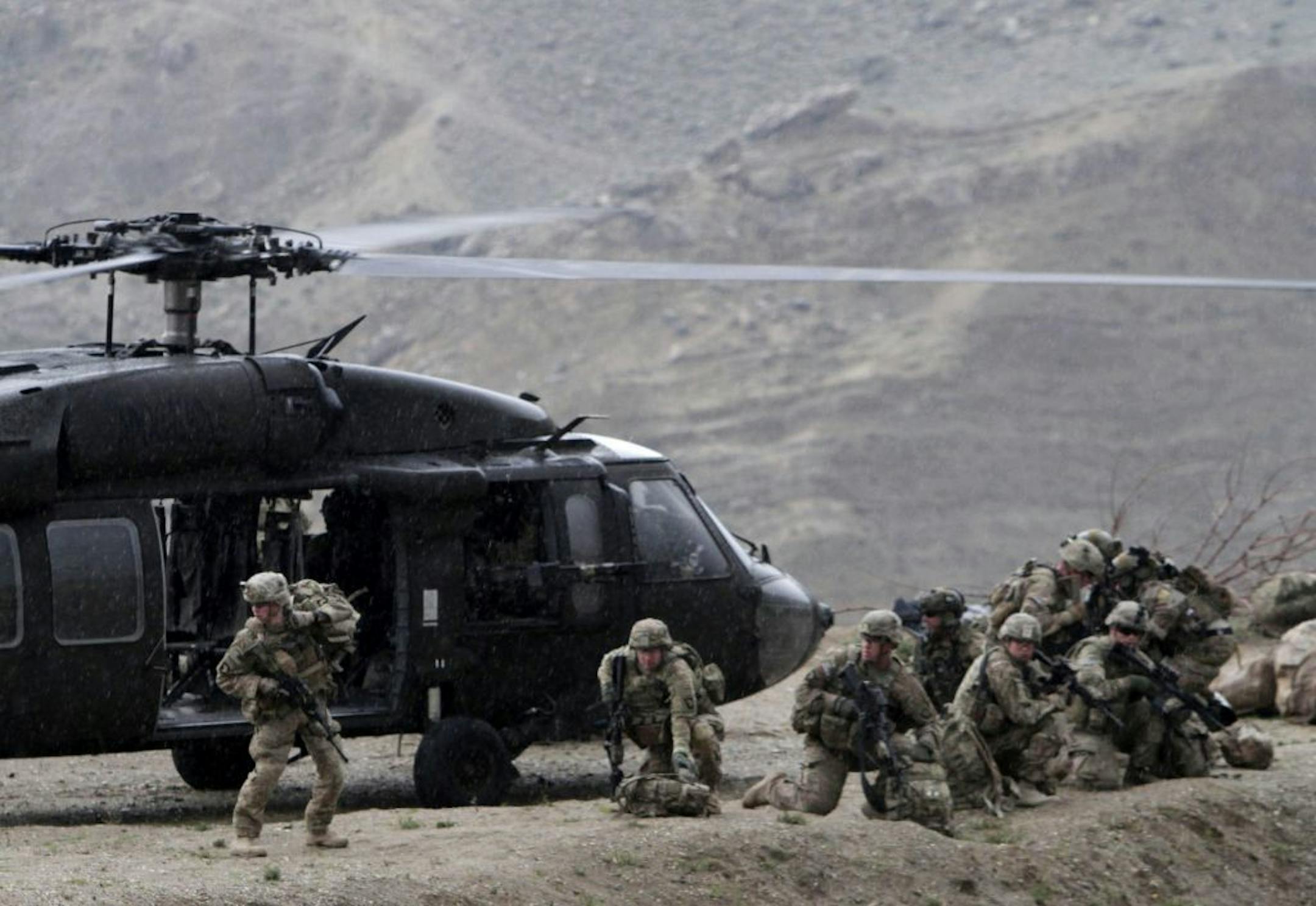 A U.S. Black Hawk helicopter arrives to the scene after a NATO helicopter crashed in a field killing two American service members, near Gerakhel, eastern Afghanistan, Tuesday, April 9, 2013. The U.S.-led International Security Assistance Force said the cause of the crash is under investigation but initial reporting indicates there was no enemy activity in the area at the time. It did not immediately identify the nationalities of those killed. But a senior U.S. official confirmed they were Americ
