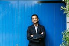 photo of author Neel Mukherjee in front of blue wall