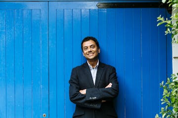 photo of author Neel Mukherjee in front of blue wall