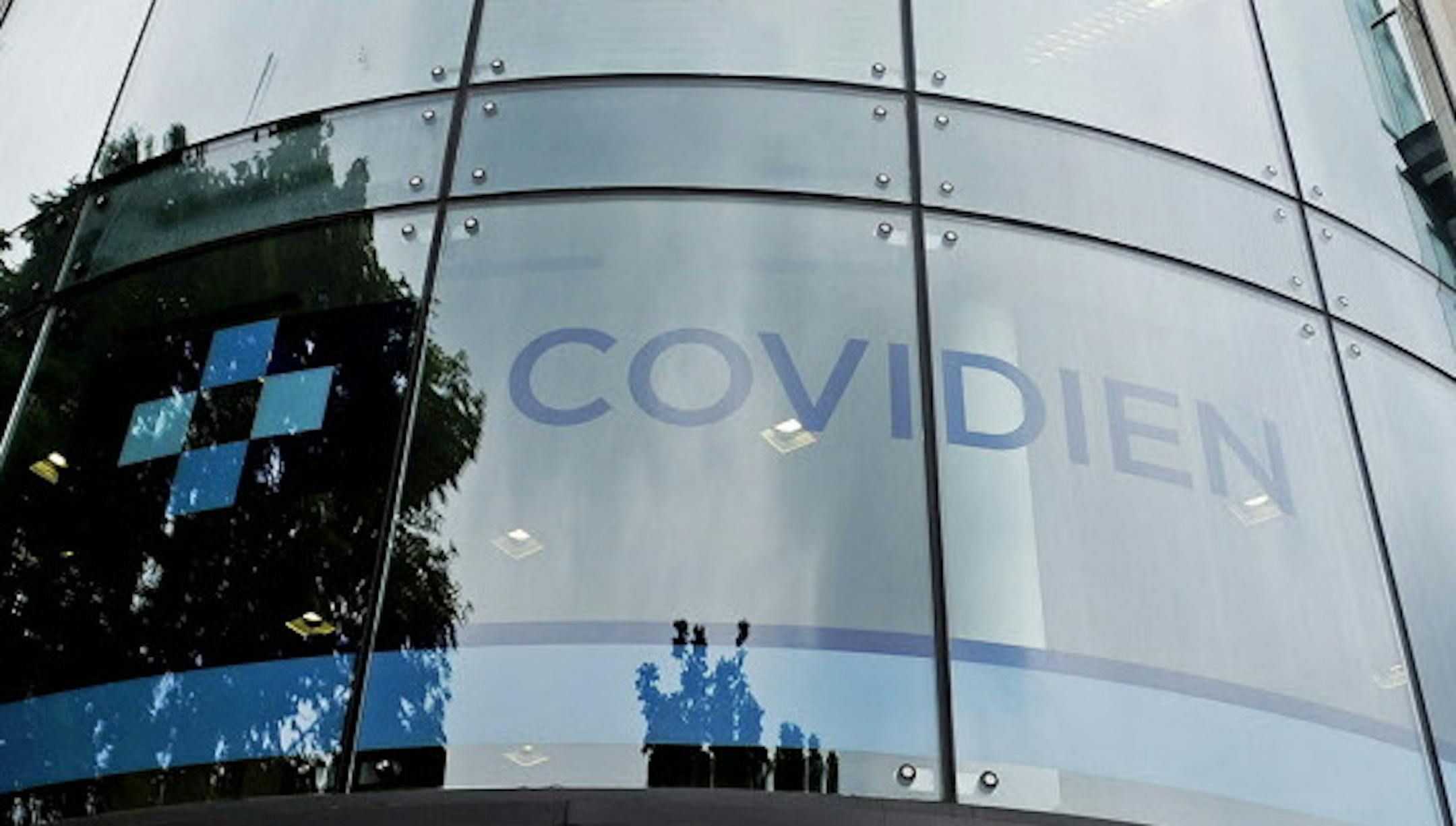 A Covidien logo sits on the glass windows of medical device manufacturer Covidien Plc's head office in Dublin, Ireland, on Monday, June 16, 2014.