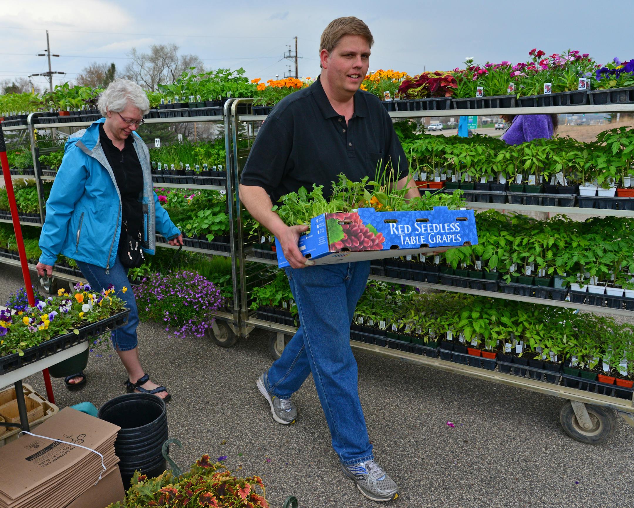Don Pflaum of Farmington carried some flowers and seed sets for Cathy Reichert of Apple Valley. ] Farmers Market at Mary Mother of Church in Burnsville. Richard.Sennott@startribune.com Richard Sennott/Star Tribune Burnsville Minn. Thursday 5/08/2014) ** (cq)